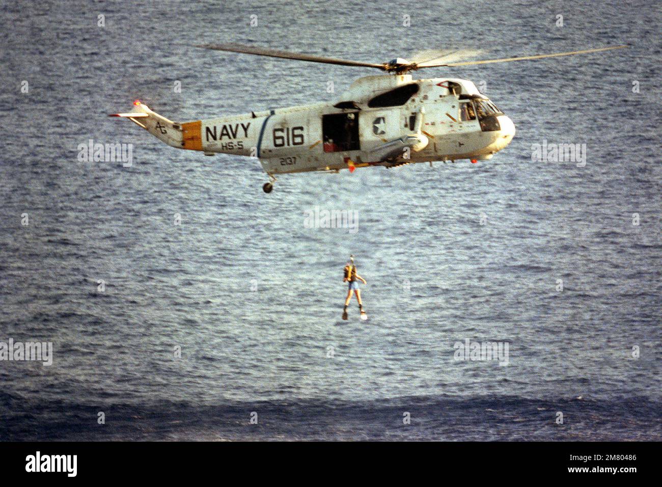 Un subacqueo di ricerca e salvataggio salta da un elicottero SH-3H Sea King di elicottero anti-sottomarino Squadron 5 (HS-5) durante un'esercitazione. Paese: Mar Mediterraneo (MED) Foto Stock