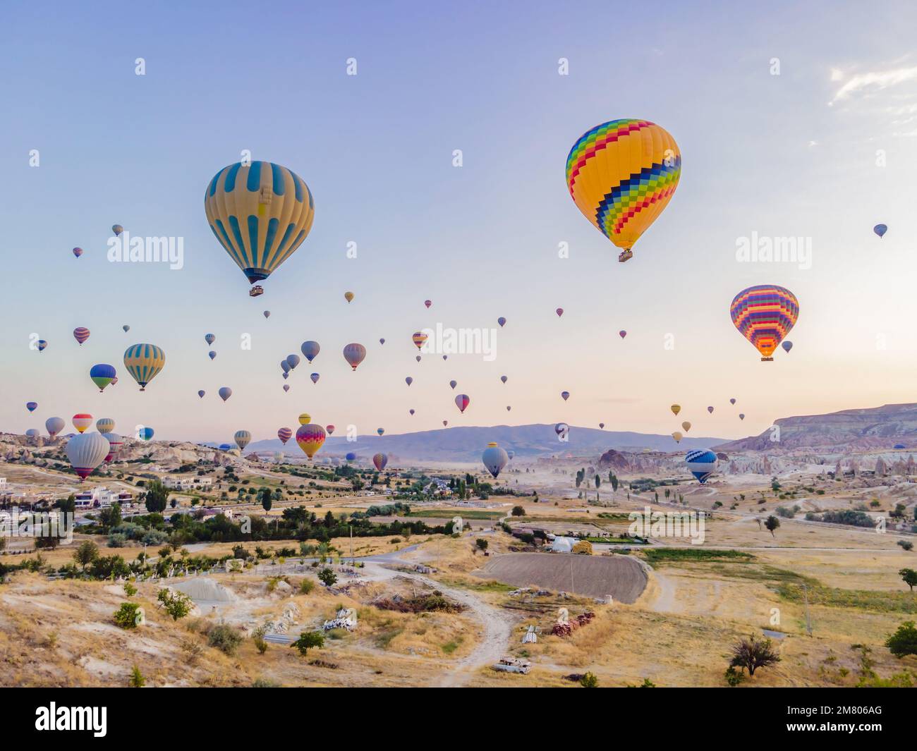 Coloratissime mongolfiere che volano nella valle dei camini delle fate a Nevsehir, Goreme, Cappadocia Turchia. Spettacolare vista panoramica del drone Foto Stock