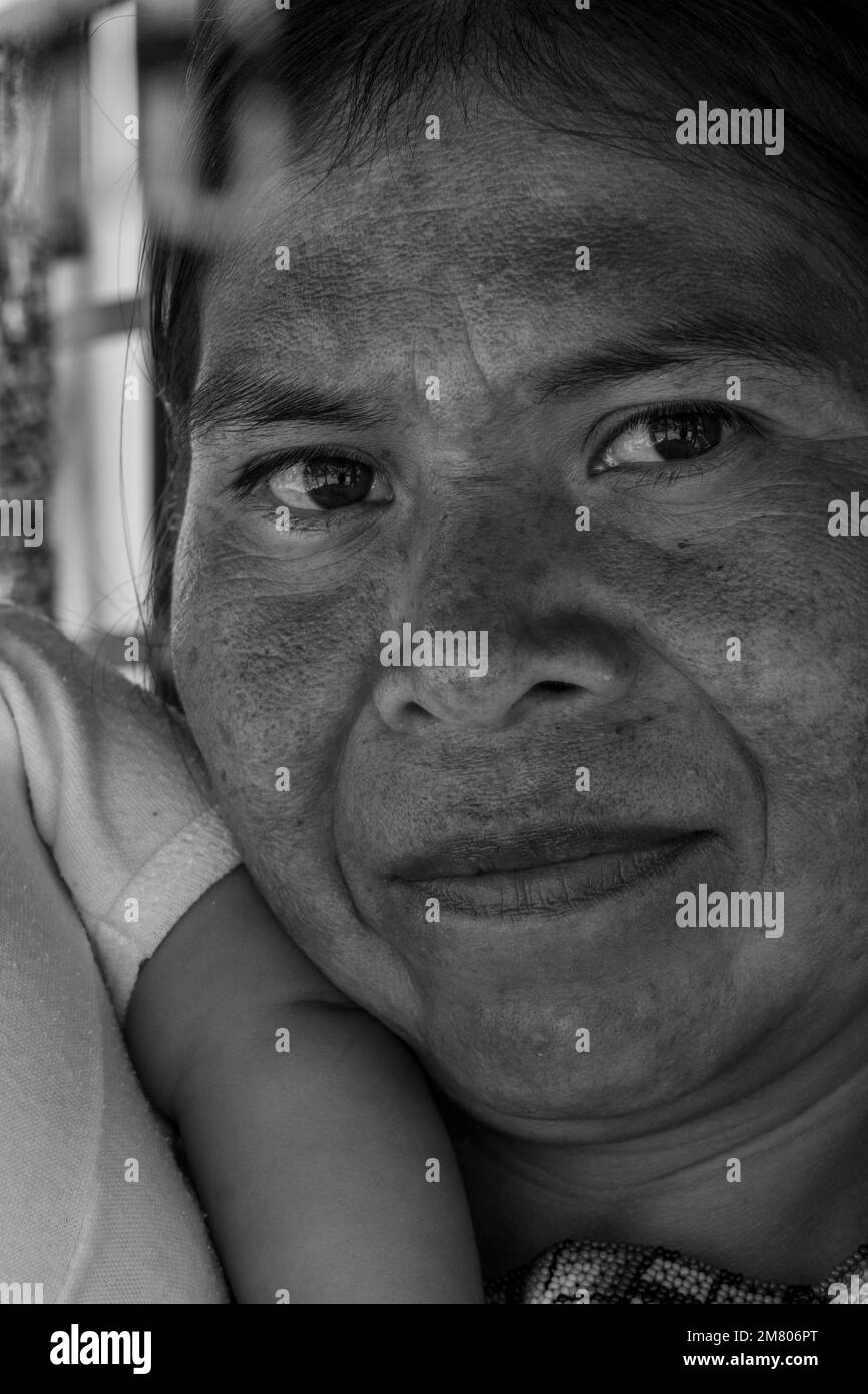 donna artigiana indigena con la sua figlia neonato con il suo artigianato appeso ai suoi lati Foto Stock