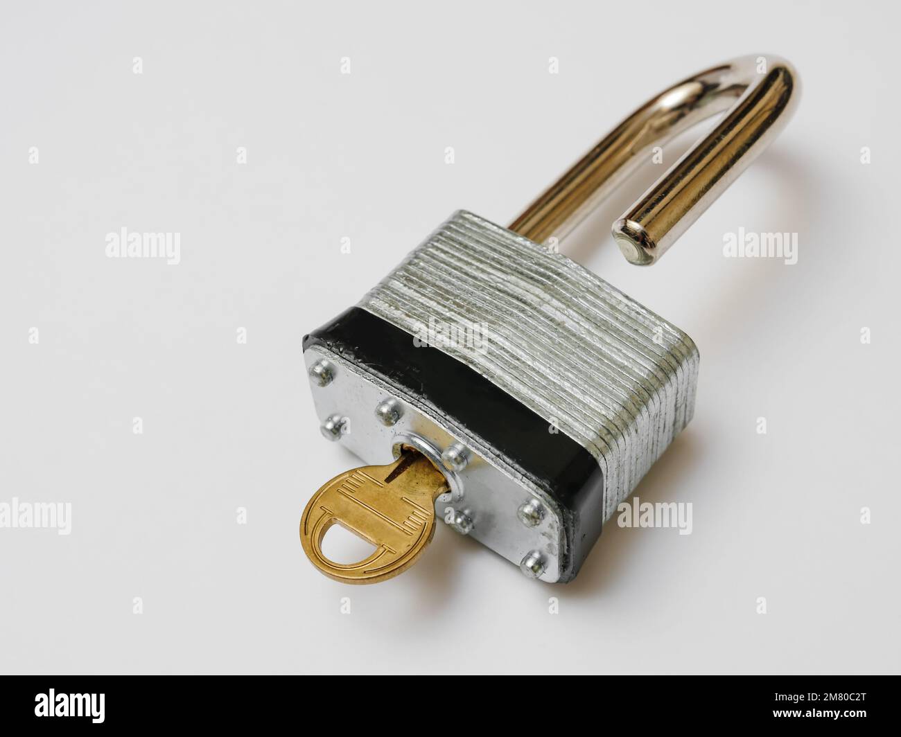 Sbloccato il lucchetto con chiave su sfondo bianco. Foto Stock