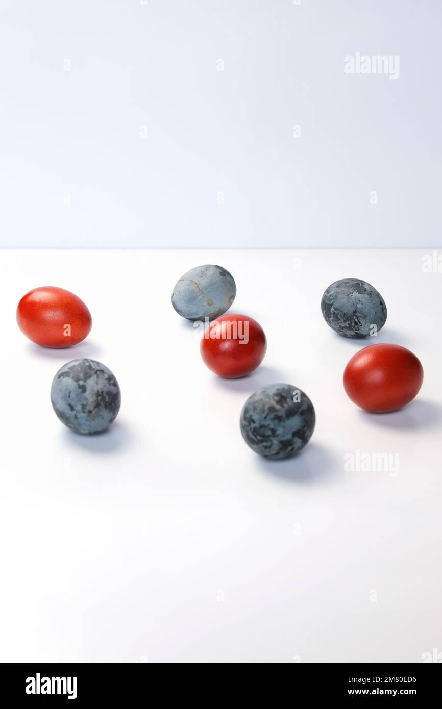 Defocalizzare le uova blu e rosse su sfondo bianco. Concetto minimo di festa di Pasqua. Design, arte visiva, minimalismo. Concetto di equilibrio e armonia. Mentale Foto Stock