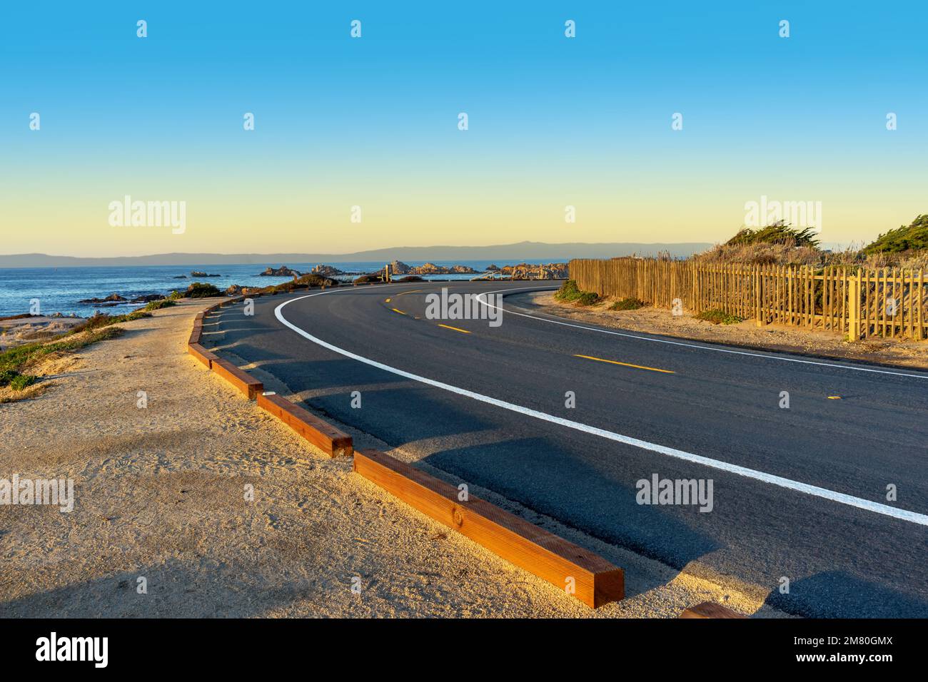 Strada curva con vista sull'oceano nella città di Pacific Grove, nella baia di Monterey Foto Stock