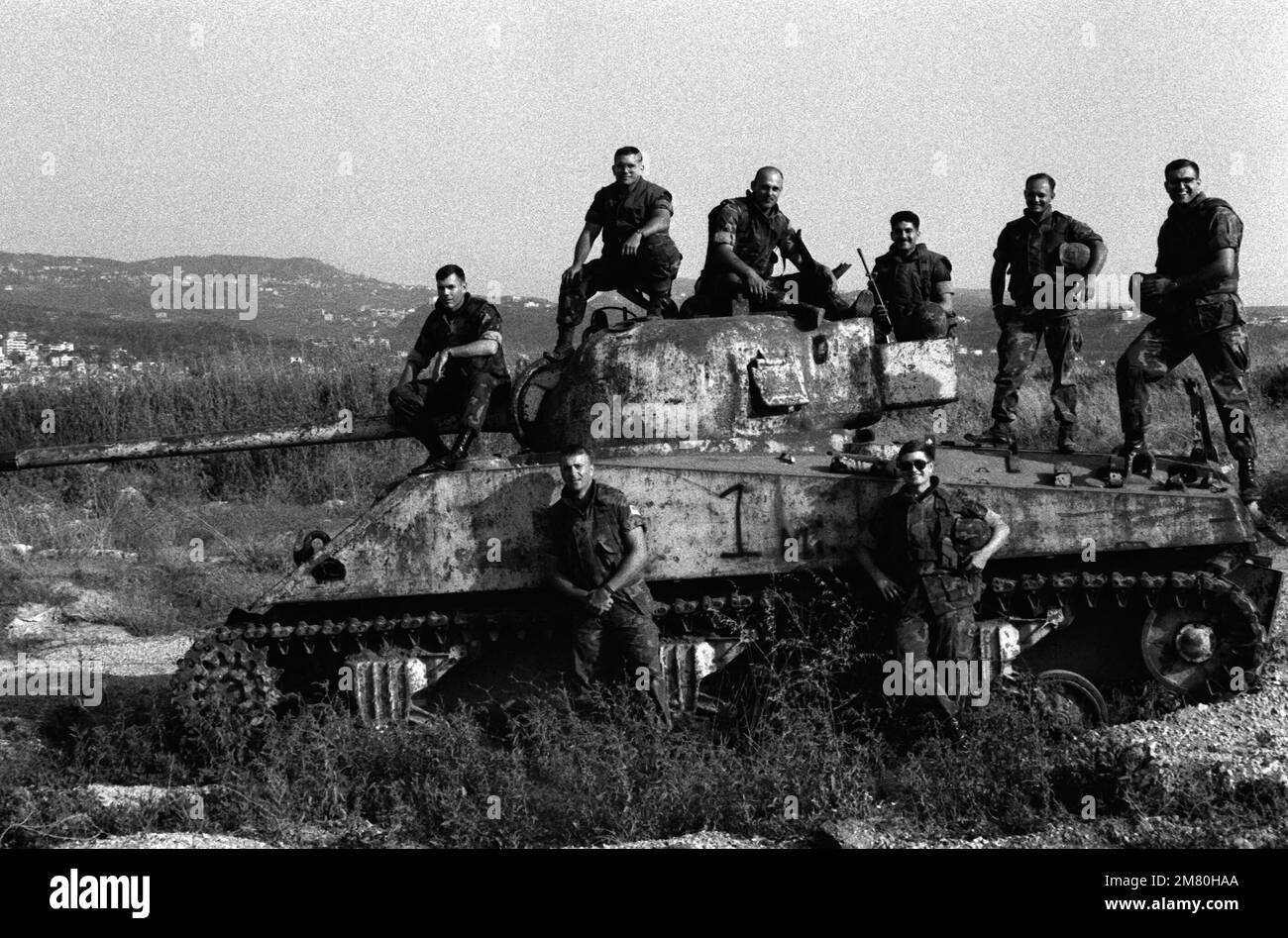 I Marines fanno una pausa dalla loro routine quotidiana di lavoro per fare scattare la loro foto sulle rovine di un carro armato durante la loro partecipazione come membri della forza multinazionale di mantenimento della pace. Base: Beirut Nazione: Libano (LBN) Foto Stock
