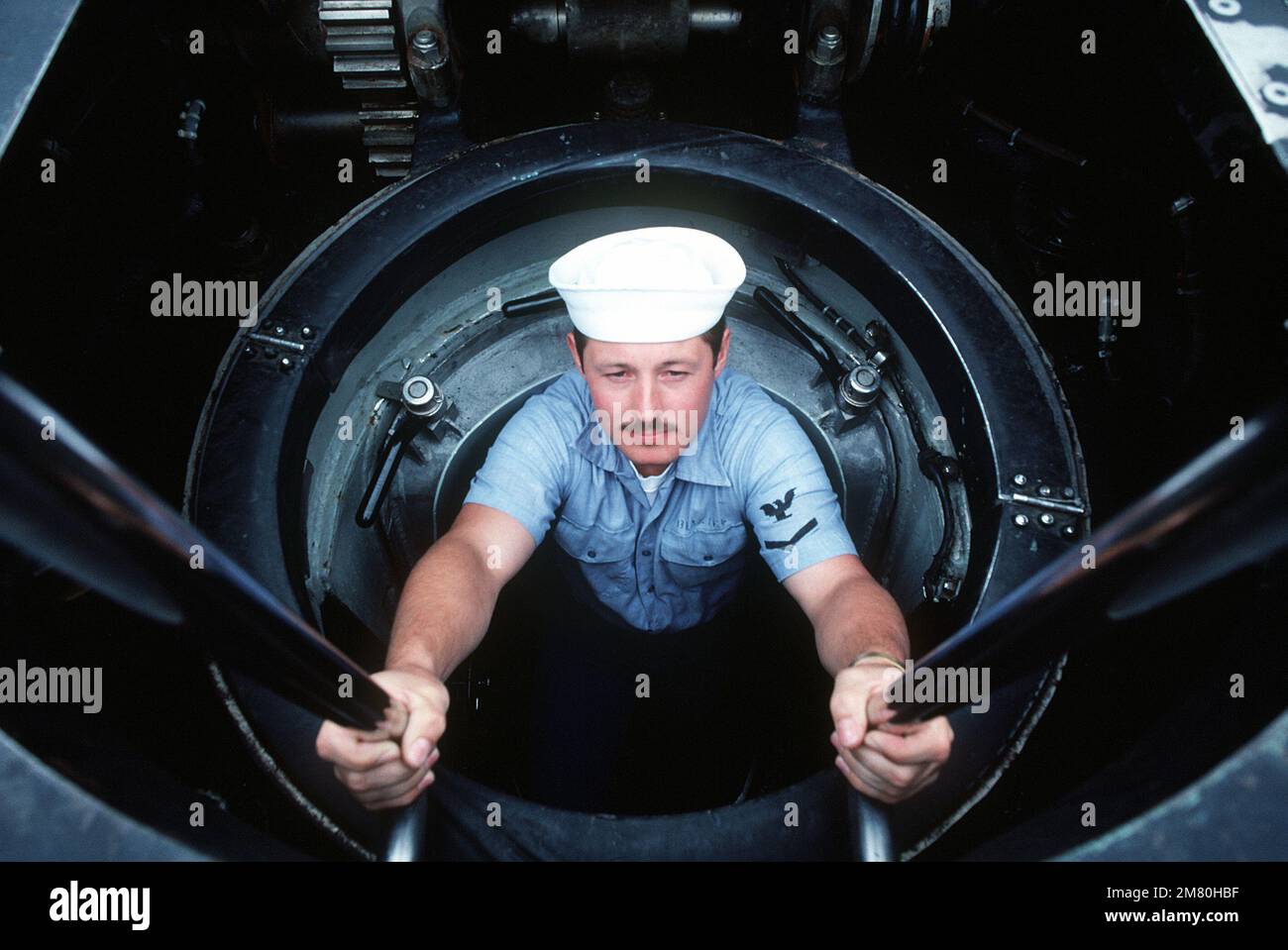 Un sommergibile scende su una scala verticale a bordo del sottomarino di attacco nucleare della classe Los Angeles USS LA JOLLA (SSN-701). Con spazio limitato, i sommergibili sono dotati di portelli montati sul ponte e di scale verticali. Paese: Oceano Pacifico (POC) Foto Stock