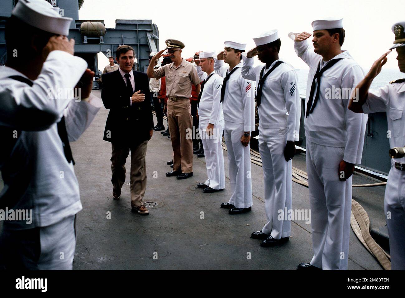 Il Segretario della Marina John F. Lehman Jr. Passa tra i sideboys a bordo della nave da carico anfibia USS EL PASO (LKA 117) che opera al largo delle coste libanesi. Lehman sta facendo un tour del contingente americano della forza multinazionale di mantenimento della pace a Beirut, in Libano. Base: USS El Paso (LKA 117) Nazione: Mar Mediterraneo (MED) Foto Stock