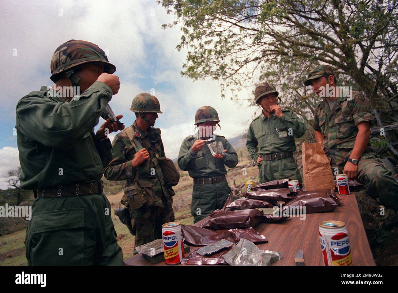 Gli ufficiali giapponesi della forza di autodifesa mangiano negli Stati Uniti Razioni dell'esercito durante il loro rispetto delle tecniche di addestramento da parte dei membri della 2nd BDE., 25th Divisione di Fanteria. Base: Pohakulua Training Area Stato: Hawaii (HI) Paese: Stati Uniti d'America (USA) Foto Stock