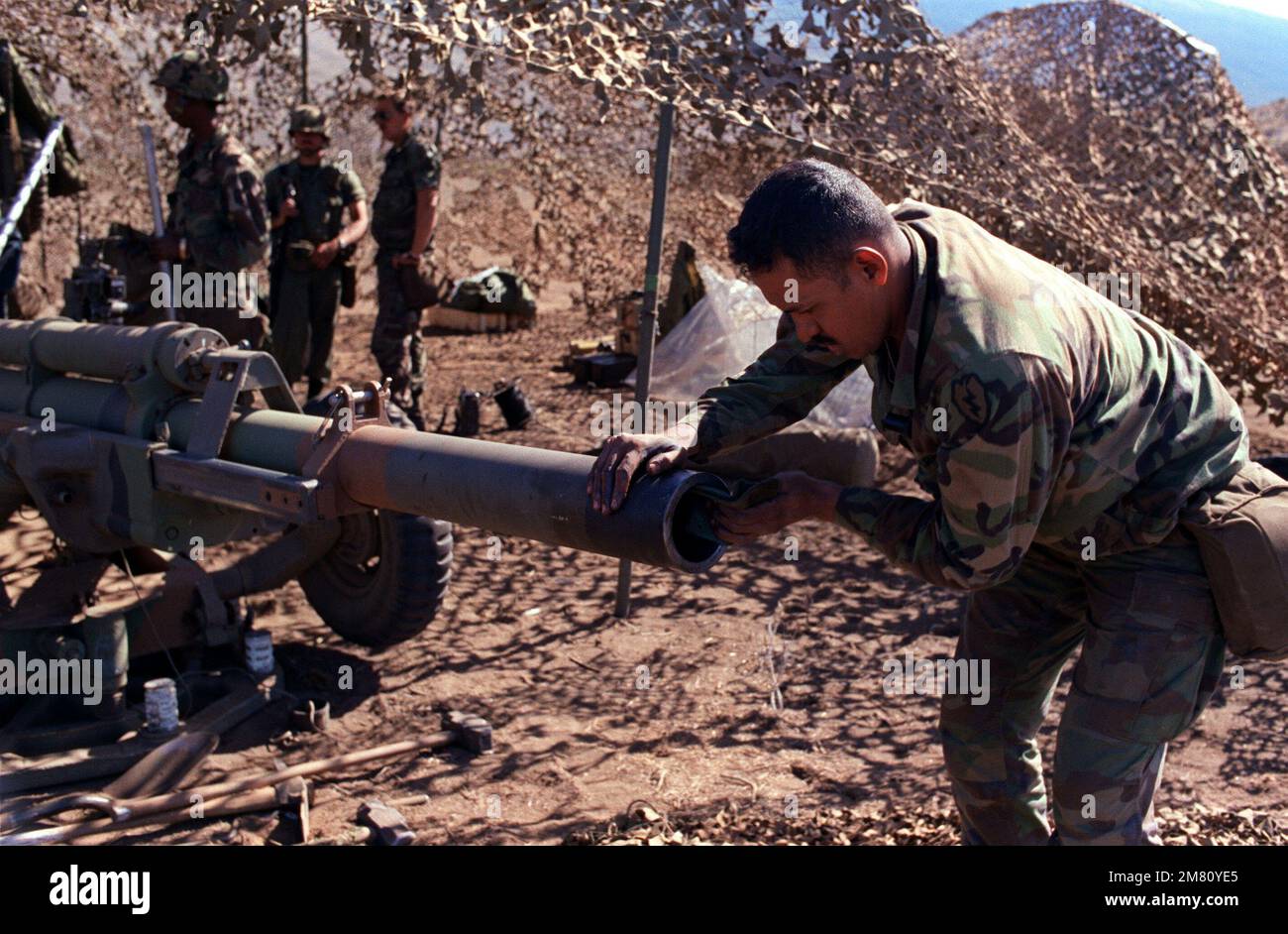 Il caporale René Garcia, assistente alla 4th Sezione della batteria C, 2nd Battaglione, 11th Artiglieria di campo, 25th Divisione di Fanteria, pulisce la museruola di un urlatore M-102 155 mm, durante l'esercizio di artiglieria a fuoco vivo presso l'Area di addestramento di Pohakulea dell'esercito americano. Stato: Hawaii (HI) Paese: Stati Uniti d'America (USA) Foto Stock