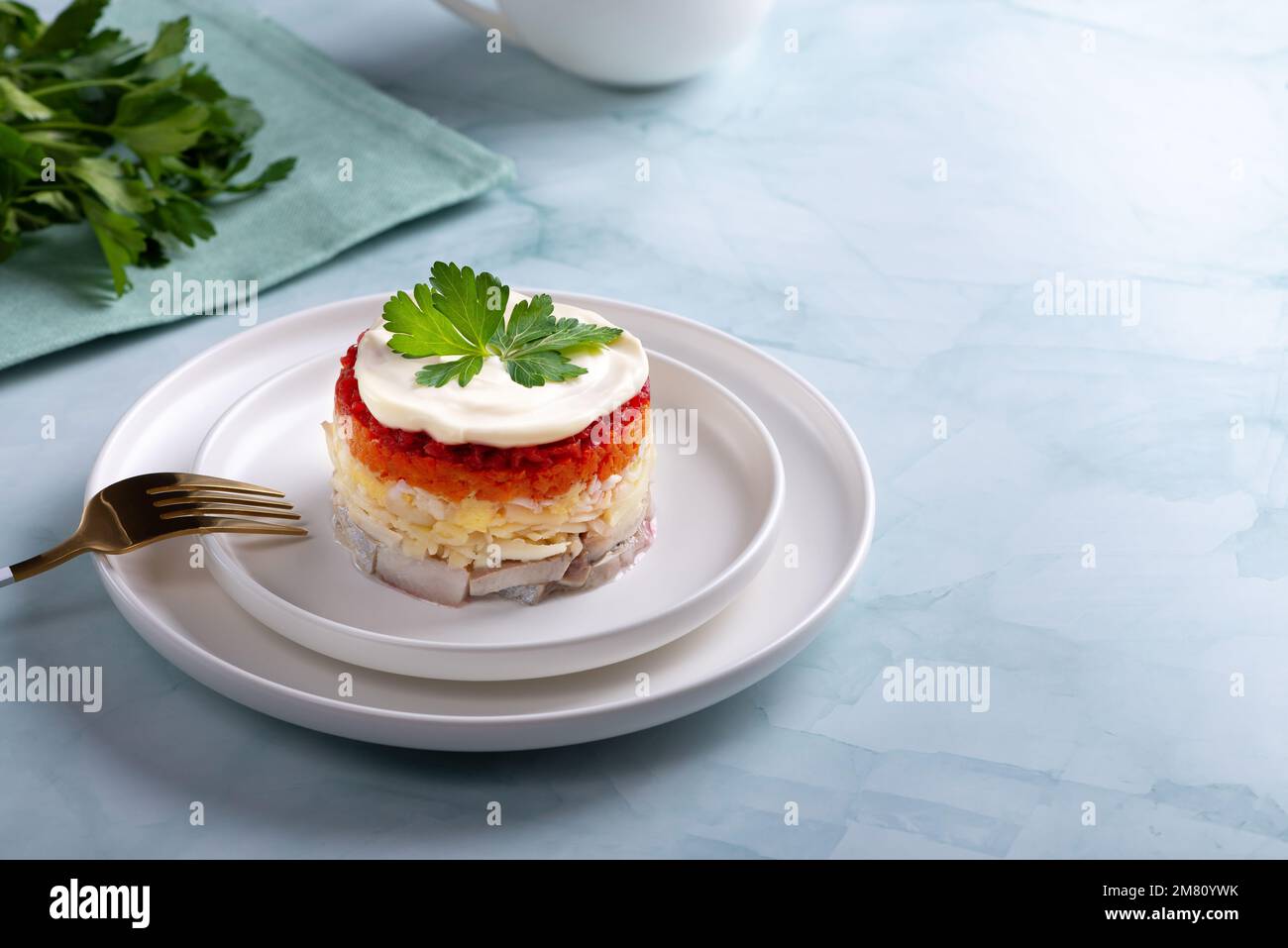 Insalata tradizionale russa con aringhe e verdure su sfondo verde Foto Stock