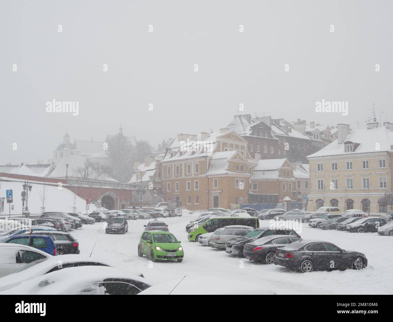 Attacco di inverno. Città, edificio e auto in neve fresca. Parcheggio a Zamkowy Squere Foto Stock
