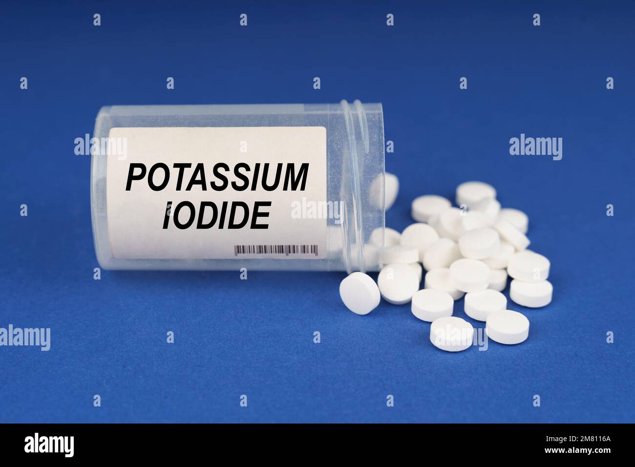 Il concetto di farmacologia e salute. Su una superficie blu ci sono pillole e un vaso polveroso con l'iscrizione - ioduro di potassio Foto Stock
