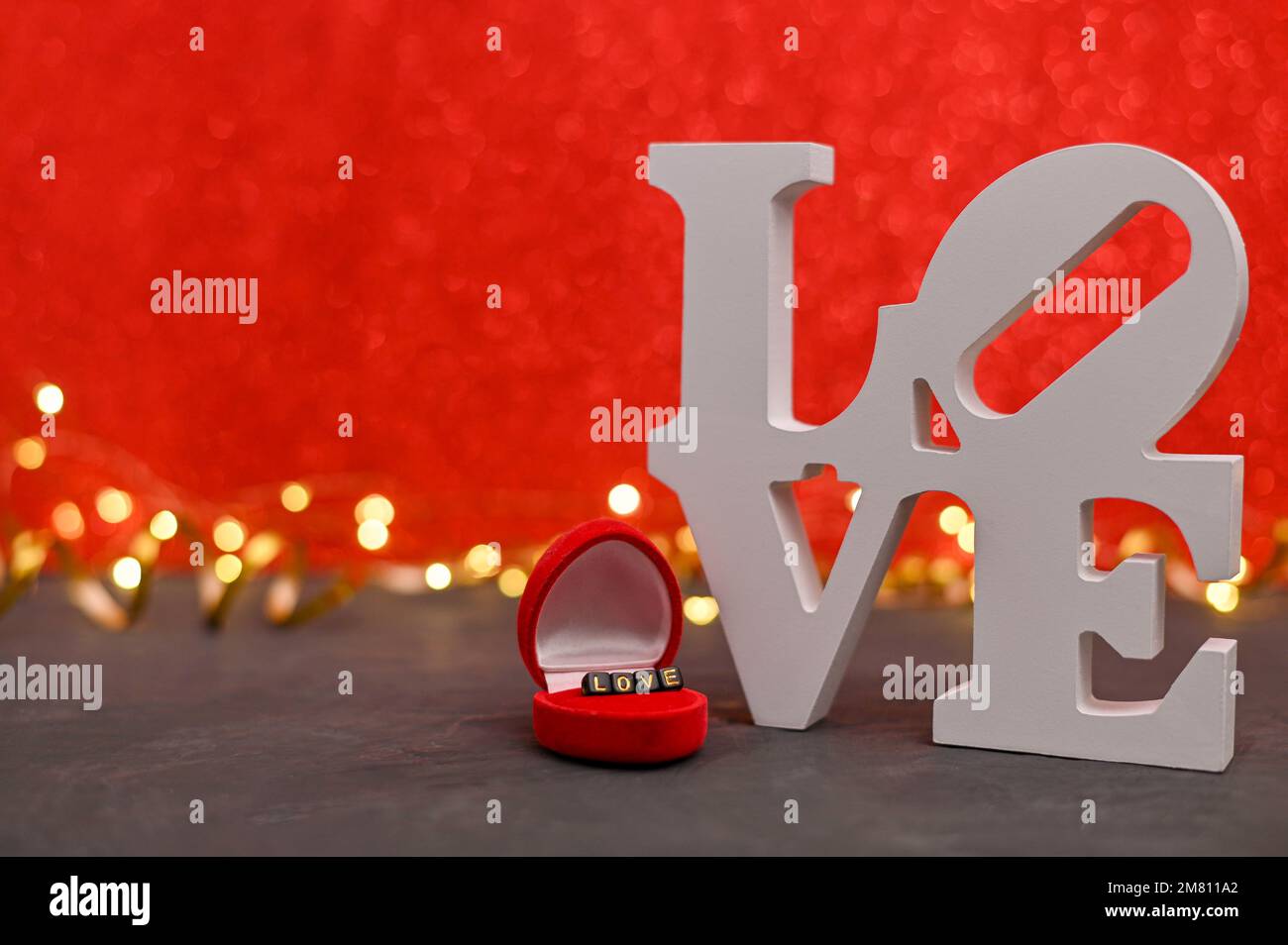 l'amore di parola è scritto nelle lettere grandi e piccole. su sfondo  rosso, un bokeh con luci Foto stock - Alamy