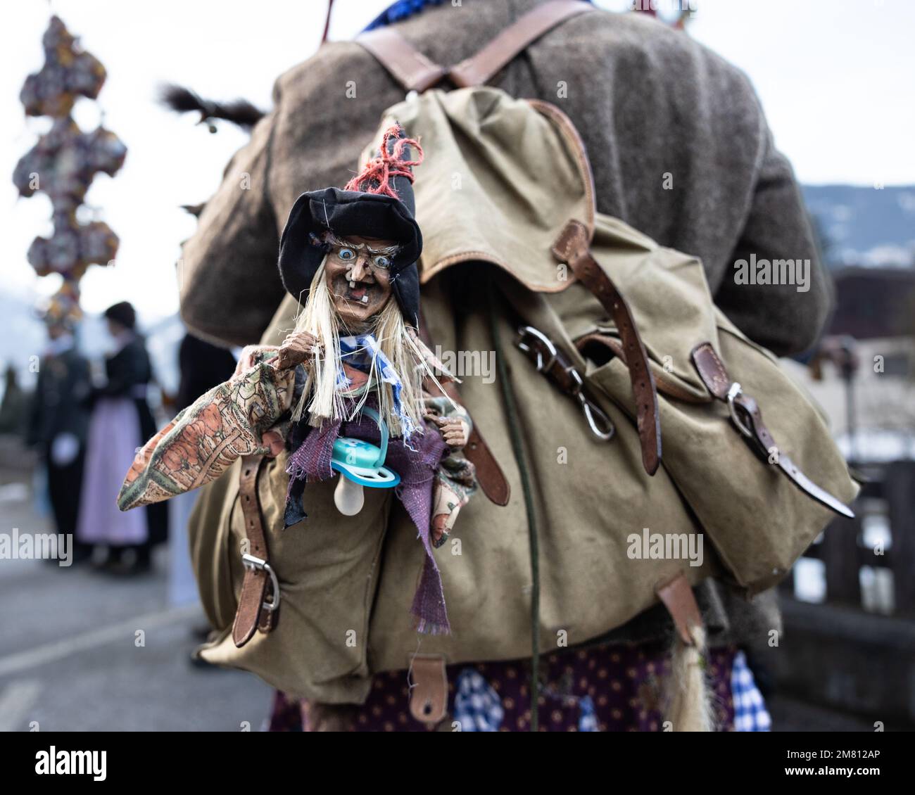 Una bambola sullo zaino di una strega durante la processione annuale nella Valle austriaca di Gastein Foto Stock