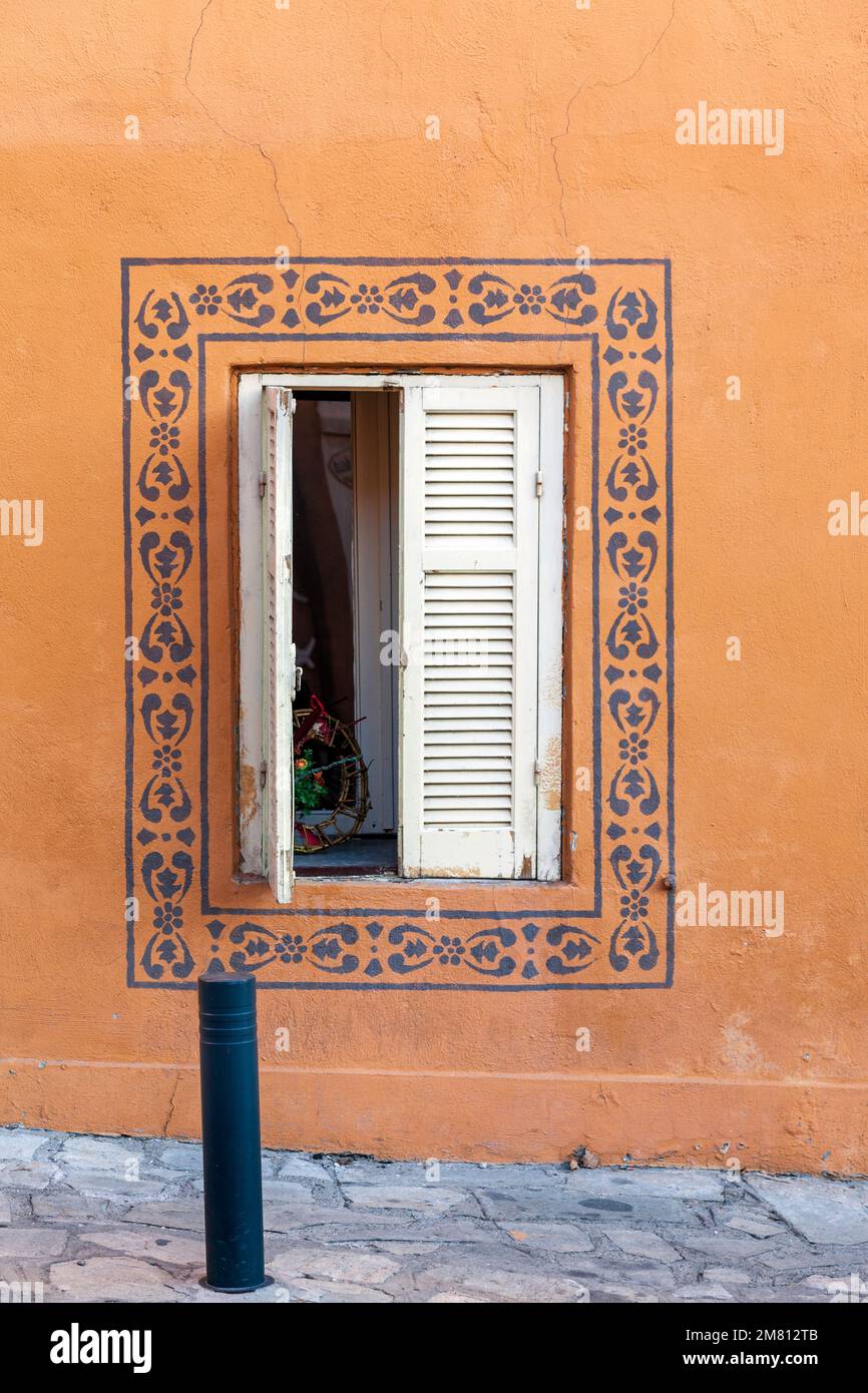 Bellissimo dettaglio vintage di una finestra casa con dipinti fatti a mano intorno alla finestra, in Ano poli, il quartiere tradizionale di Salonicco, Grecia. Foto Stock