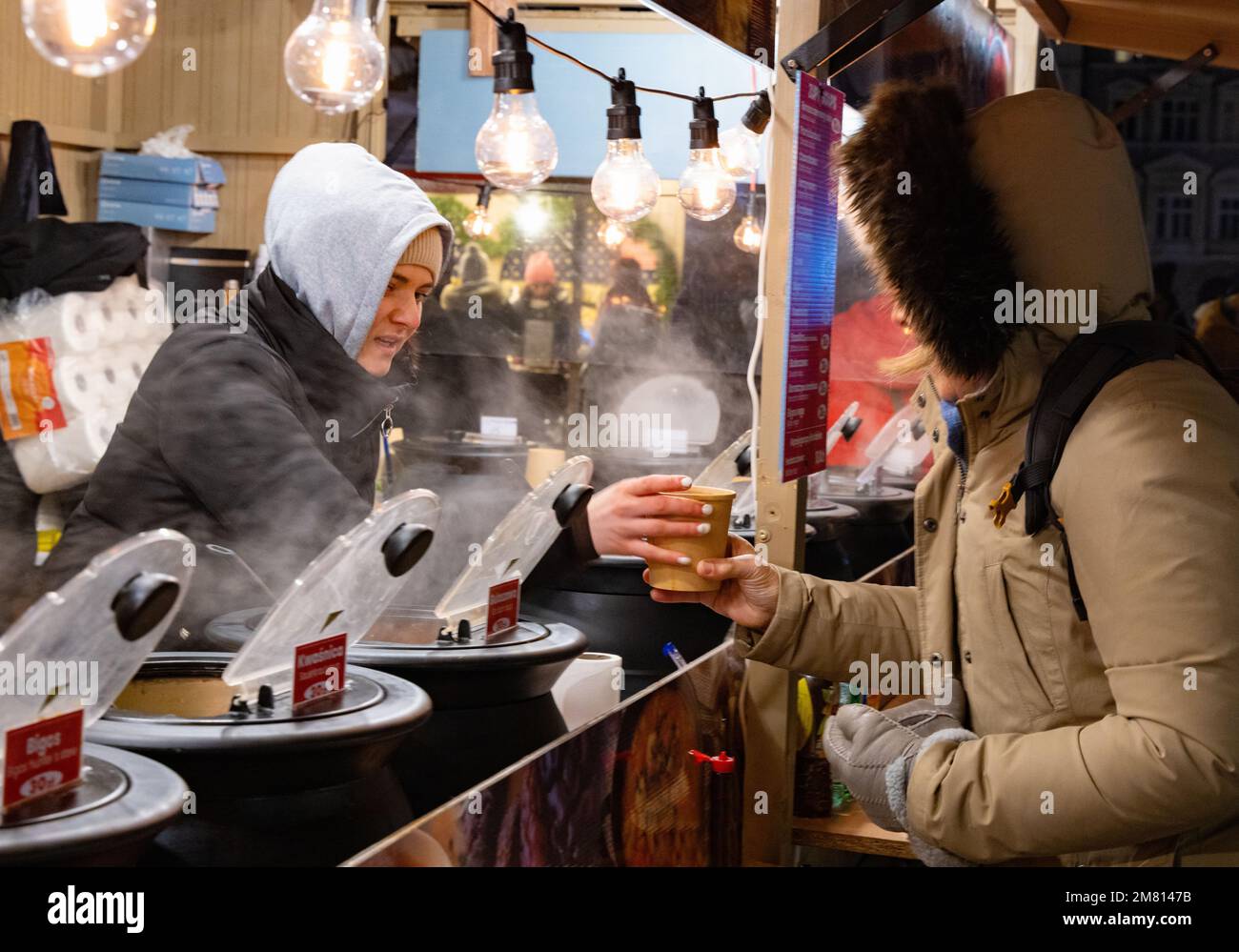 Una donna che acquista zuppa in una bancarella alimentare, il mercato di Natale di Cracovia, Cracovia Polonia Europa Foto Stock