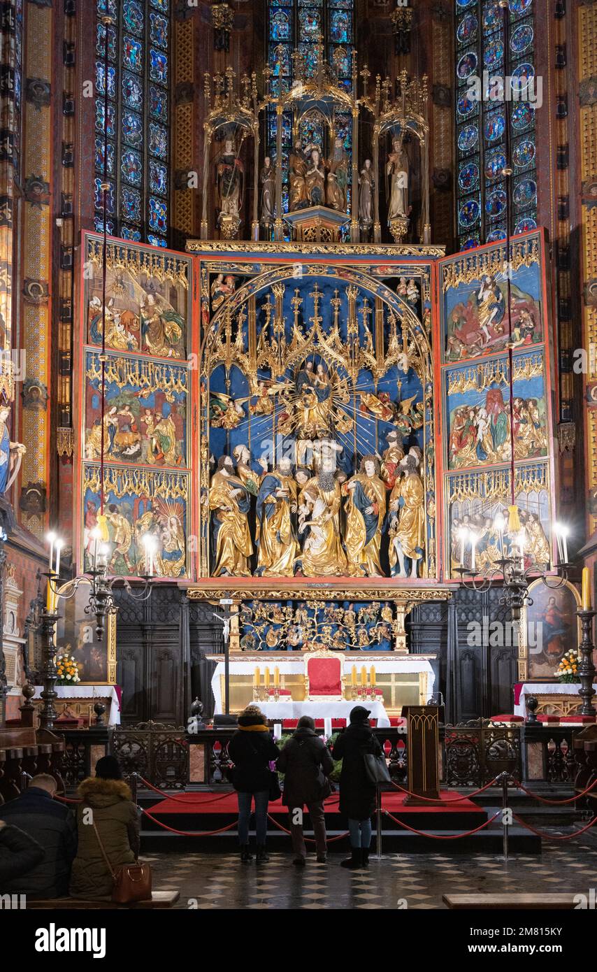 Turisti nella chiesa di San Marys Cracovia interni; decorazione ornata della navata e altare, all'interno della Basilica di San Marys, Cracovia Città Vecchia, Cracovia Polonia Europa Foto Stock