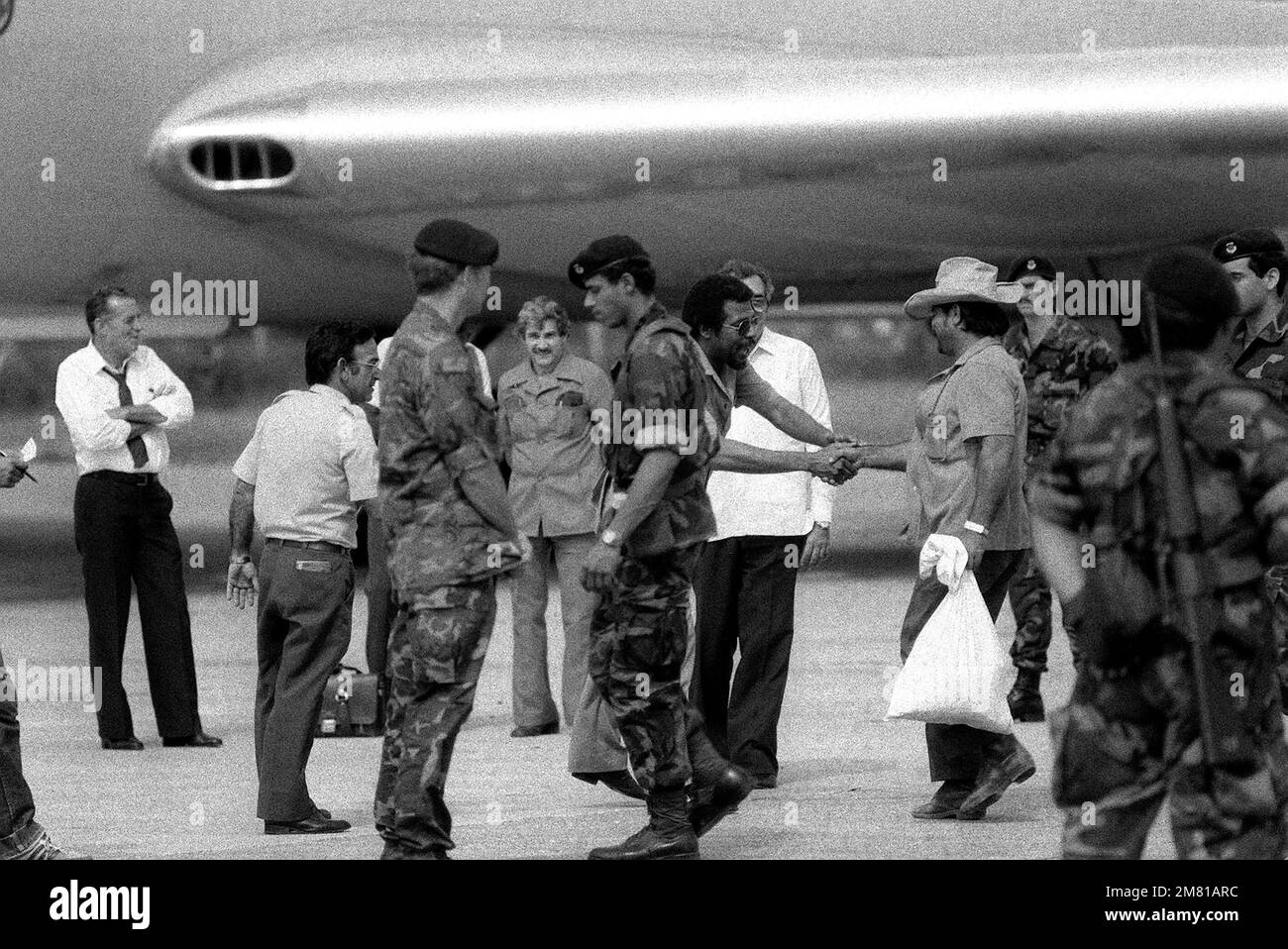 STATI UNITI La polizia di sicurezza dell'Aeronautica militare si sta a trovare mentre i cittadini cubani si preparano a salire a bordo di un aereo di linea cubano I1-62M per un volo verso Cuba. Sono stati catturati a Grenada durante l'operazione multiservizio, multinazionale URGENT Fury. Soggetto operativo/Serie: URGENT FURY base: Seawell International Airport Paese: Bangladesh (BGD) Foto Stock