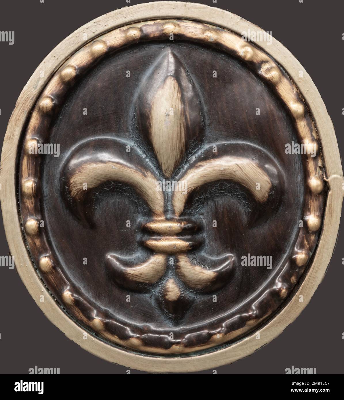 Fleur-de-lis su un ovale con accenti dorati su sfondo marrone. Foto Stock