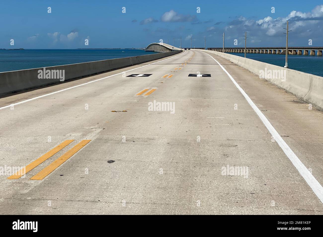 Viaggio in Florida in auto, bella vista della lunga Overseas Highway con auto, acqua oceanica del Golfo del Messico e piloni di potenza su entrambi i lati della strada, Foto Stock