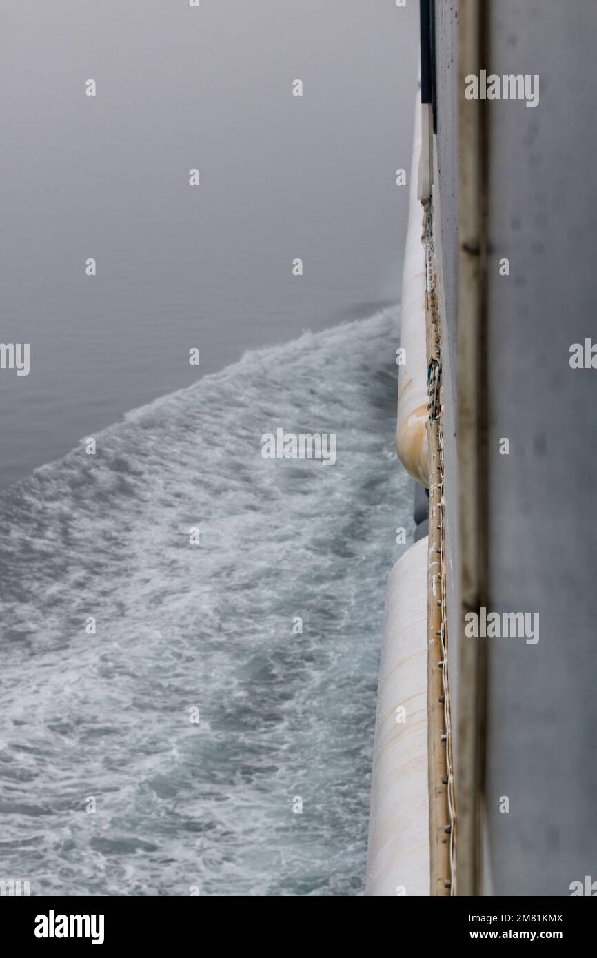 La scia sul lato di una nave è creata dalla nave come essa rompe la tensione superficiale dell'acqua. Foto Stock