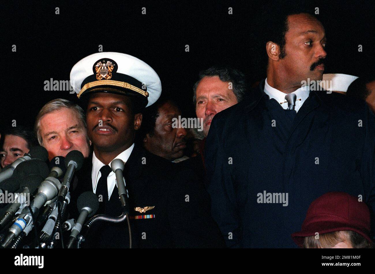 LT. Robert O. Goodman conduce una conferenza stampa al suo arrivo alla base. Goodman era il bombardier/navigatore a bordo di un aereo Intruder della Marina A-6E che è stato abbattuto durante una missione sul Libano il 4 dicembre 1983. Fu liberato dai suoi prigionieri siriani il 3 gennaio 1984, dopo che il Rev. Jesse Jackson, a destra, incontrò il presidente siriano Hafez al-Assad. Base: Andrews Air Force base Stato: Maryland (MD) Paese: Stati Uniti d'America (USA) Foto Stock