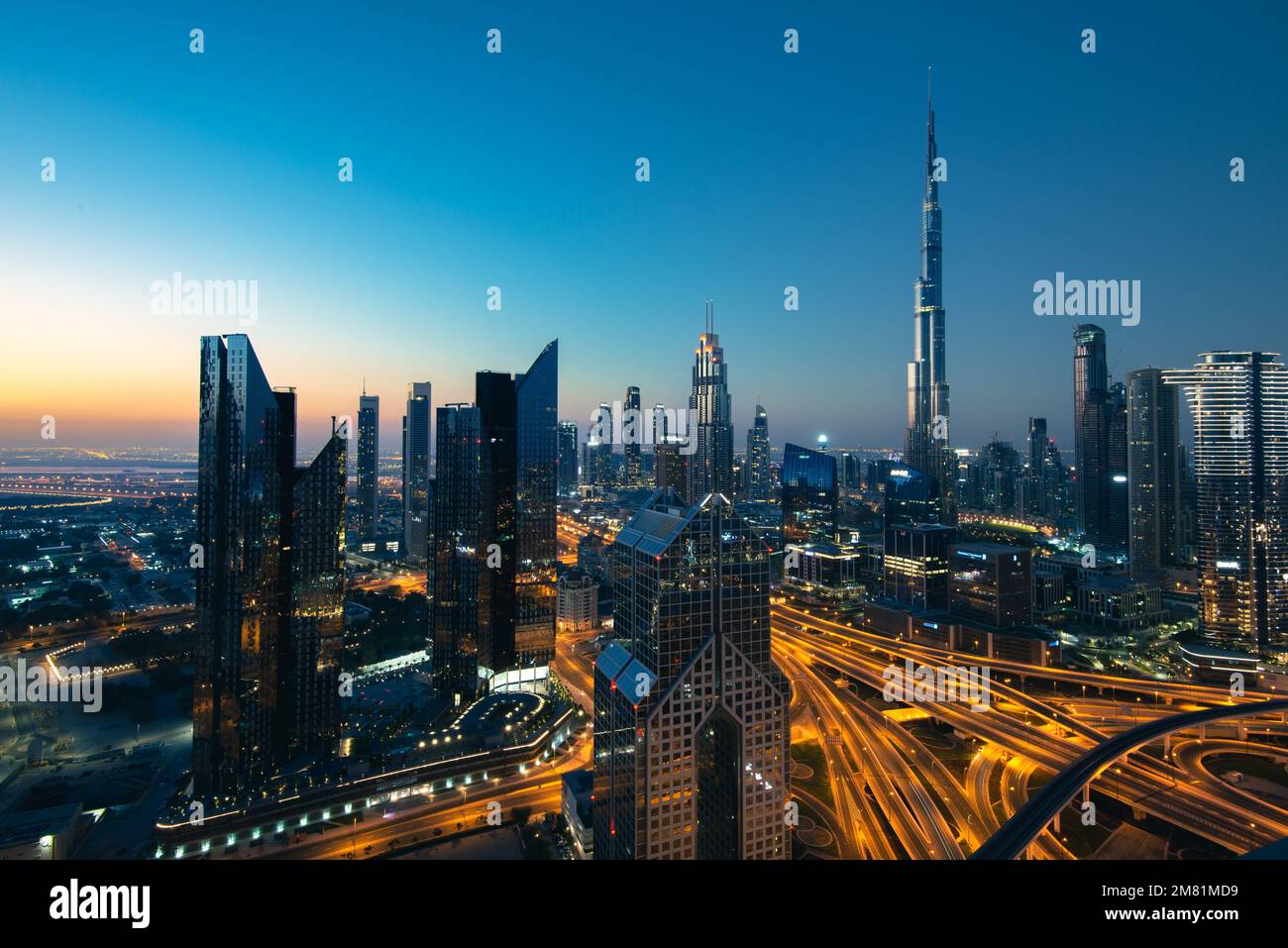 Lo skyline della torre Burj Khalifa e le autostrade illuminate al crepuscolo a Dubai Emirati Arabi Uniti Foto Stock