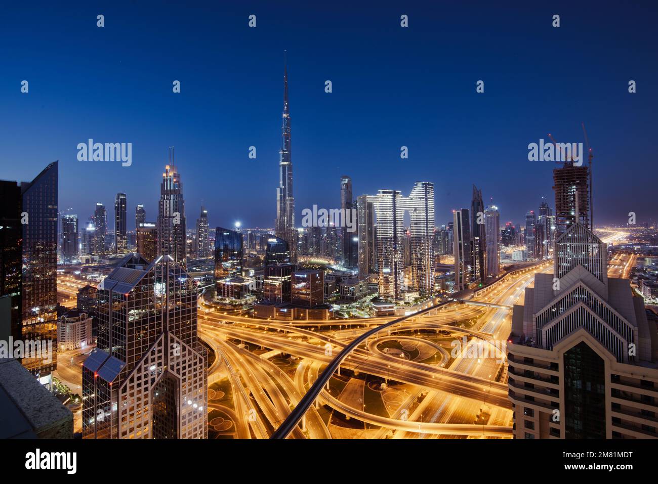 Lo skyline della torre Burj Khalifa e le autostrade illuminate al crepuscolo a Dubai Emirati Arabi Uniti Foto Stock