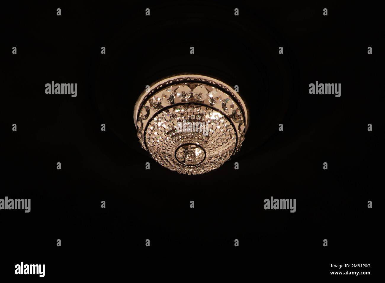 Lampadario di cristallo luminoso con sfondo nero Foto Stock