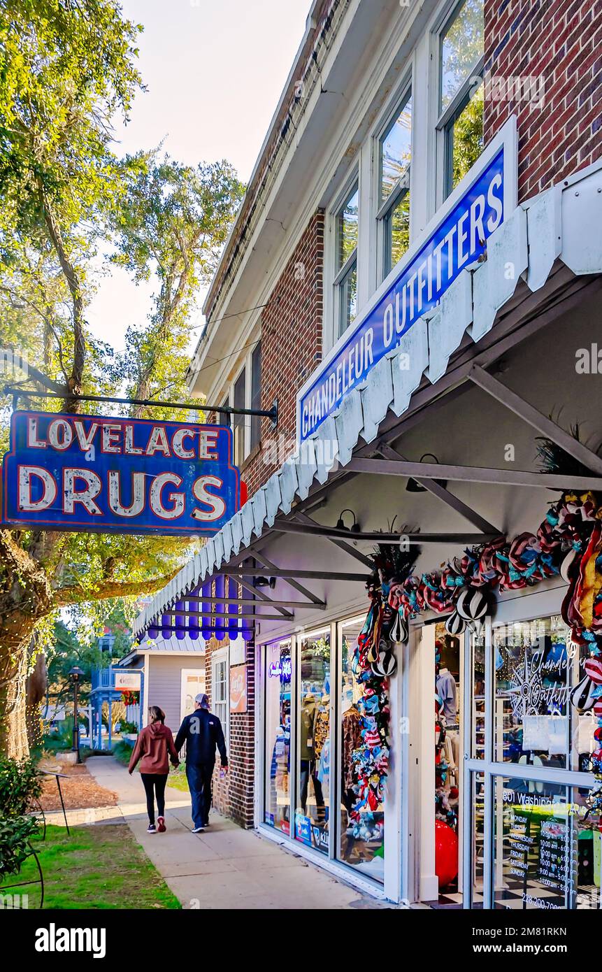 Una coppia cammina oltre Lovelace Drugs, 28 dicembre 2022, a Ocean Springs, Mississippi. La farmacia è stata costruita nel 1926. Foto Stock