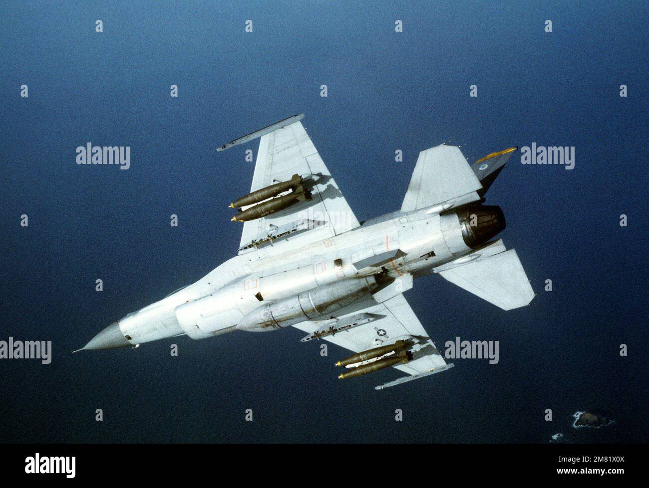 Una vista dal basso aria-aria di un aereo da combattimento Falcon 80th Tactical Fighter Squadron F-16 mentre si avvicina alla gamma Chik-Tow durante l'esercizio congiunto USA/Corea del Sud Team Spirit '84. La F-16 trasporta sei bombe Mark 82 sui piloni ad ala. Soggetto operativo/Serie: TEAM SPIRIT '84 Paese: Corea del Sud Foto Stock