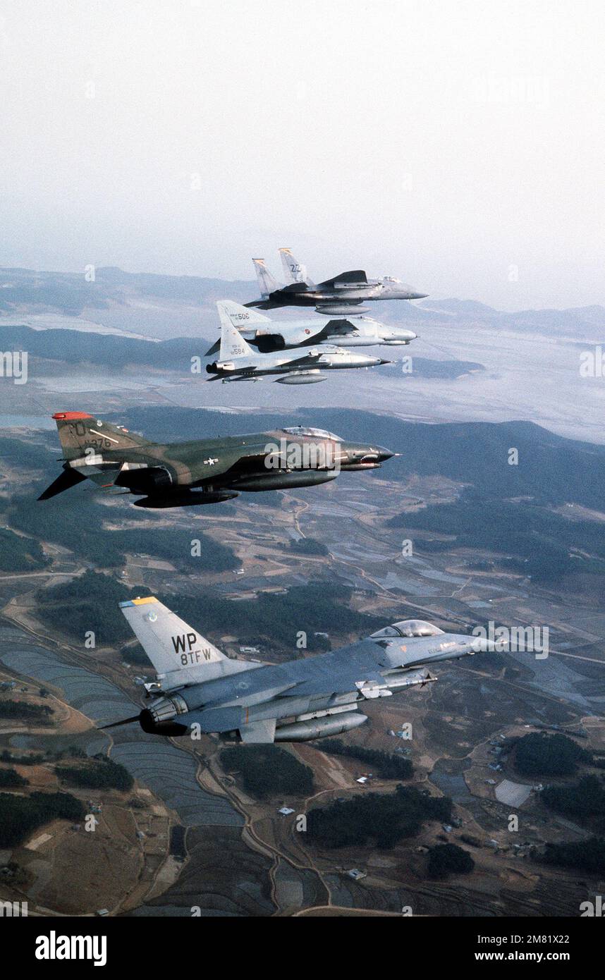 Una vista aria-aria lato destro di un aereo delle forze aeree coreane F-5 Tiger II e F-4 Phantom II in formazione con un aereo delle forze aeree statunitensi F-16 Fighting Falcon, F-4 Phantom II e F-15 Eagle durante l'esercizio CONGIUNTO di SQUADRA USA/Corea del Sud SPIRITO `84. Soggetto operativo/Serie: TEAM SPIRIT '84 Paese: Repubblica di Corea (KOR) Foto Stock