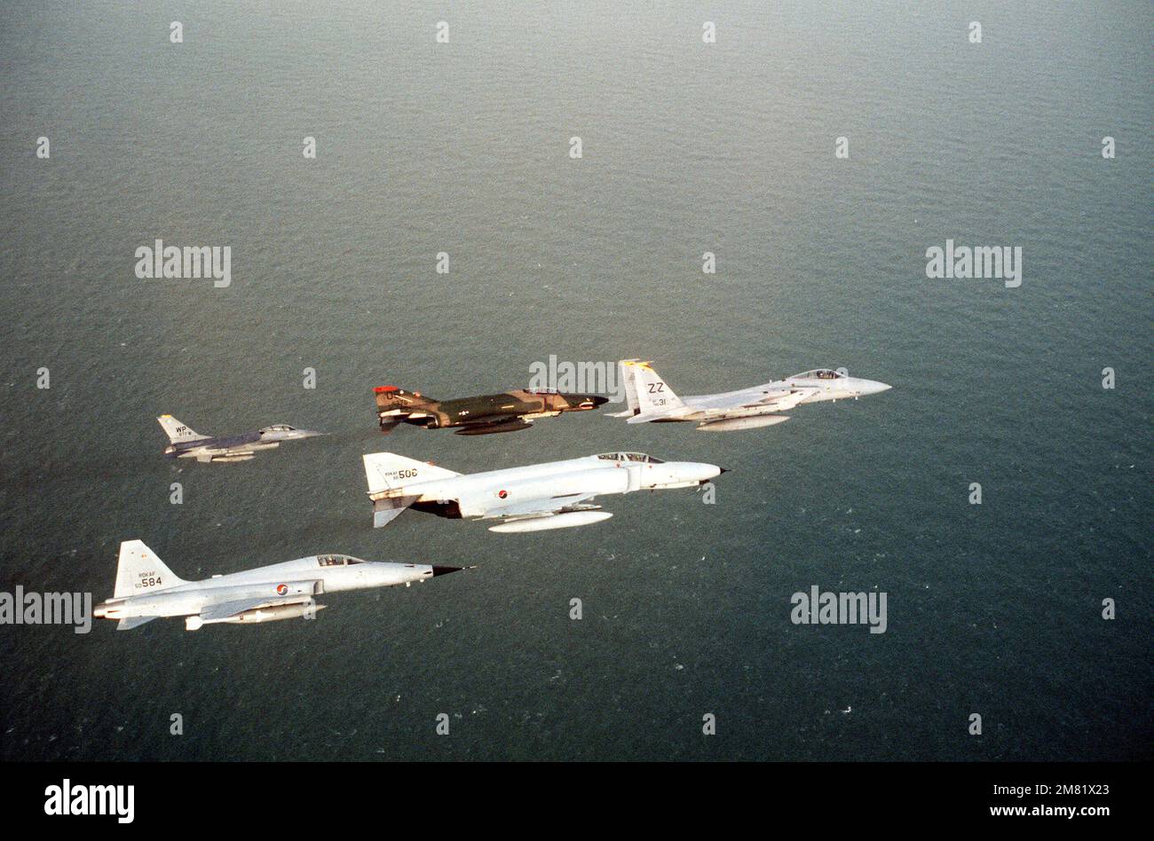 Una vista aria-aria lato destro di un aereo delle forze aeree coreane F-5 Tiger II e F-4 Phantom II in formazione con un aereo delle forze aeree statunitensi F-16 Fighting Falcon, F-4 Phanton II e F-15 Eagle durante lo SPIRITO CONGIUNTO della SQUADRA di allenamento USA/Corea del Sud `84. Soggetto operativo/Serie: TEAM SPIRIT '84 Paese: Repubblica di Corea (KOR) Foto Stock