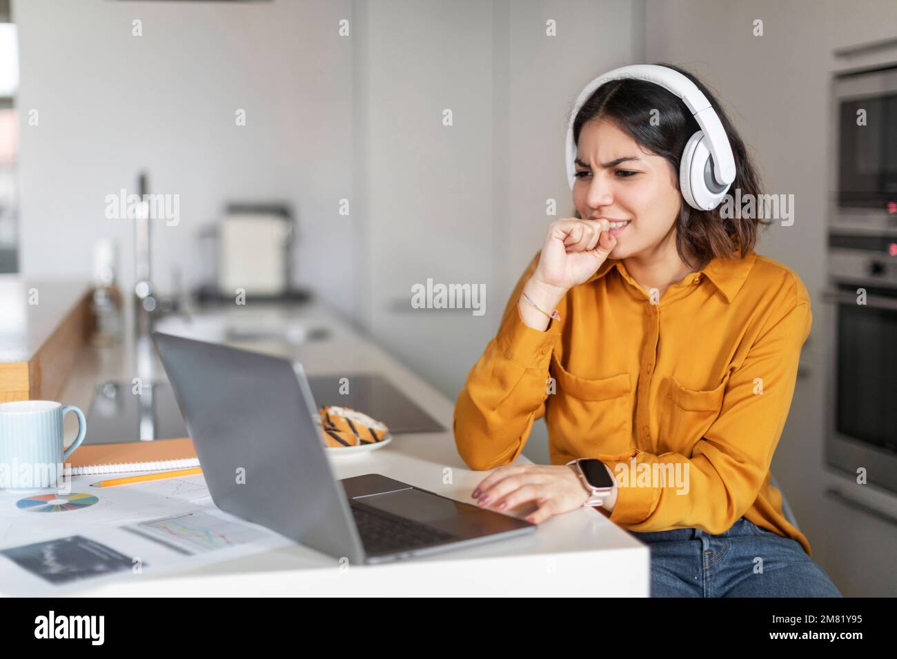 Donna araba stressata che soffre problemi mentre lavora con computer portatile a casa Foto Stock