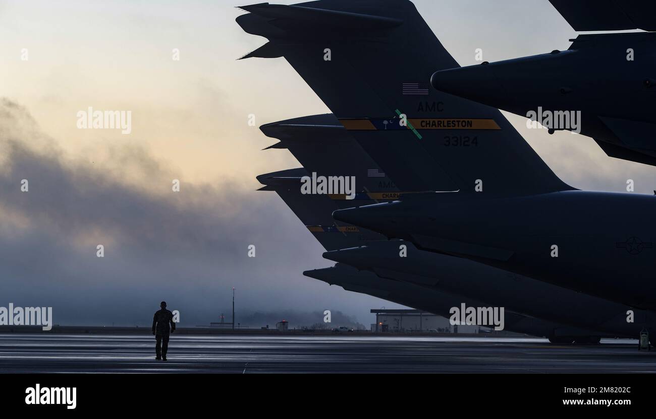 Staff Sgt. Daniel Hernandez, 1st Combat Camera Squadron aereo da combattimento camera journeyman, cammina il flightline prima di un esercizio di massa generazione su Joint base Charleston, South Carolina, 5 gennaio 2023. Questa generazione di missioni è solo un esercizio che ha portato a Exercise Mobility Guardian 23 e ha coinvolto il lancio di 24 C-17s in un volo di formazione sul porto di Charleston. Dopo il flyover, la formazione si è spezzata in quattro squadre, ciascuna che ha realizzato l'addestramento usando i concetti agili di occupazione di combattimento.(U.S. Foto Air Force di Tech. Michael Cossaboom) Foto Stock