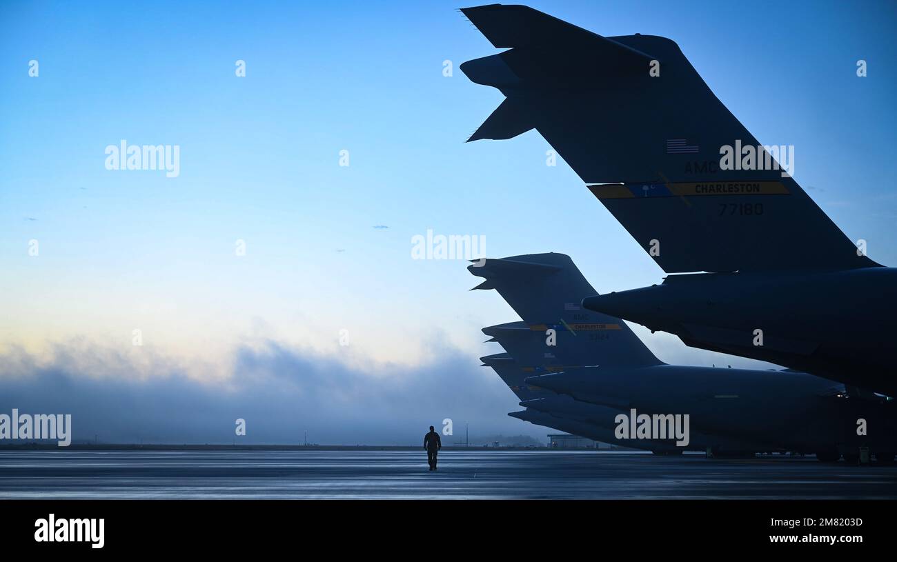 Staff Sgt. Daniel Hernandez, 1st Combat Camera Squadron aereo da combattimento camera journeyman, cammina il flightline prima di un esercizio di massa generazione su Joint base Charleston, South Carolina, 5 gennaio 2023. Questa generazione di missioni è solo un esercizio che ha portato a Exercise Mobility Guardian 23 e ha coinvolto il lancio di 24 C-17s in un volo di formazione sul porto di Charleston. Dopo il flyover, la formazione si è spezzata in quattro squadre, ciascuna che ha realizzato l'addestramento usando i concetti agili di occupazione di combattimento.(U.S. Foto Air Force di Tech. Michael Cossaboom) Foto Stock