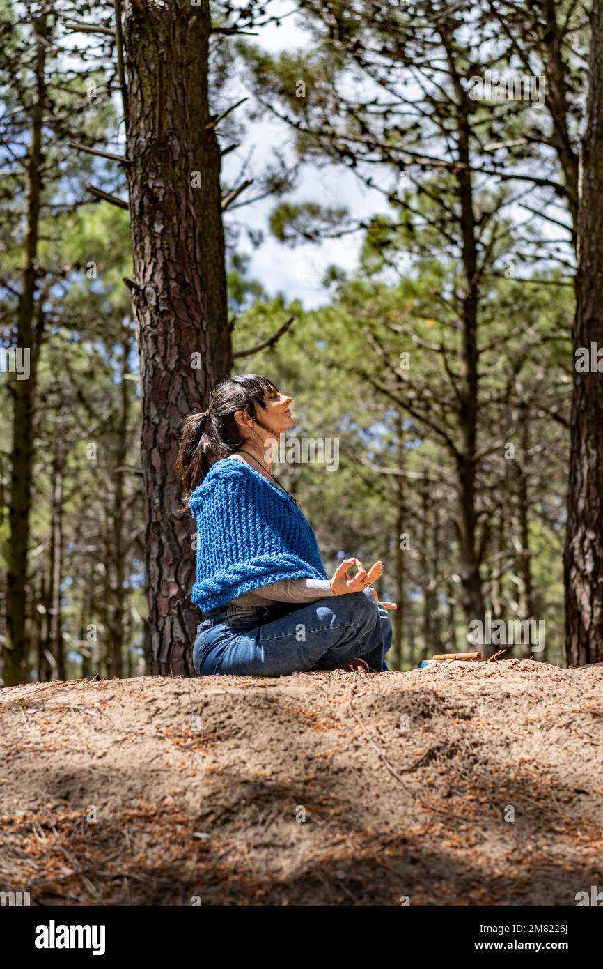 Vista laterale di una donna che stringe le mani nel bosco. Foto Stock