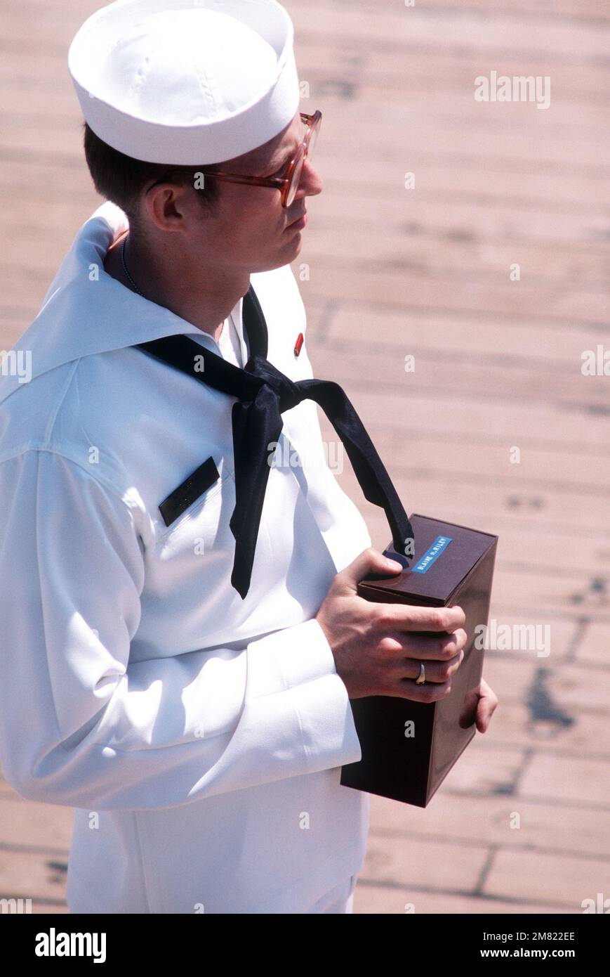 SPECIALISTA del programma religioso 3rd Classe (RP3) Greg Tiffany tiene una scatola contenente le ceneri di Blaine Railey, un ex membro delle forze armate che viene sepolto in mare. La cerimonia si svolge a bordo della corazzata USS IOWA (BB 61). Base: USS Iowa (BB 61) Foto Stock