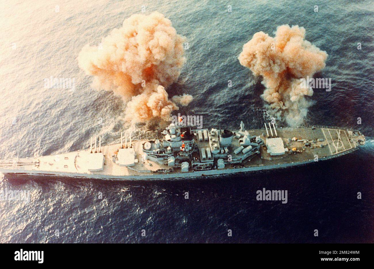 Una vista dall'alto della nave da guerra USS NEW JERSEY (BB-62) che spara a dritta le sue pistole Mark da 7 16 pollici/50 pollici. Paese: Oceano Pacifico (POC) Foto Stock