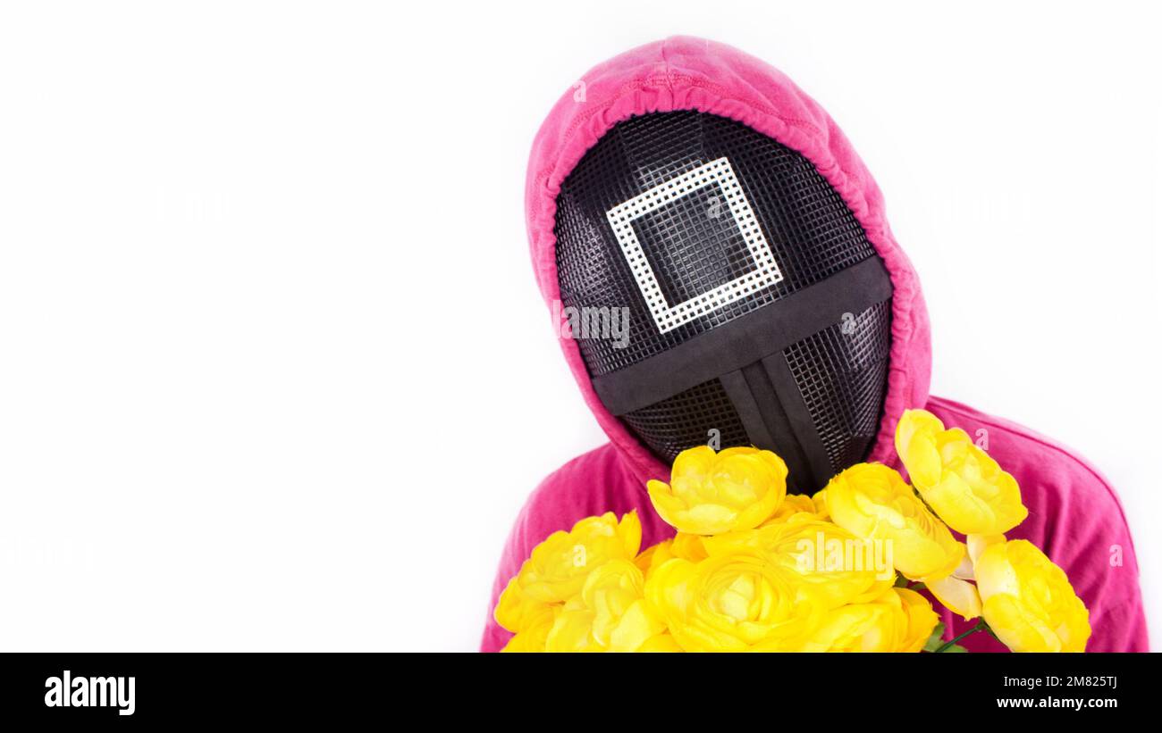 Squid Game guardia rossa con fiori gialli su sfondo bianco. Spazio per il testo. Guardia Rosa da Squid Game del nuovo spettacolo Netflix. Serie tv sudcoreana. Foto Stock