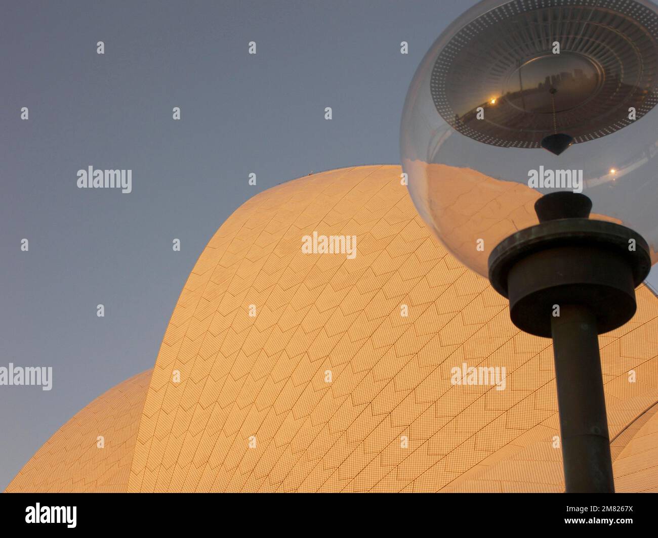 Una lampada di fronte alla Sydney Opera House riflette lo skyline della città, Australia - Foto Stock