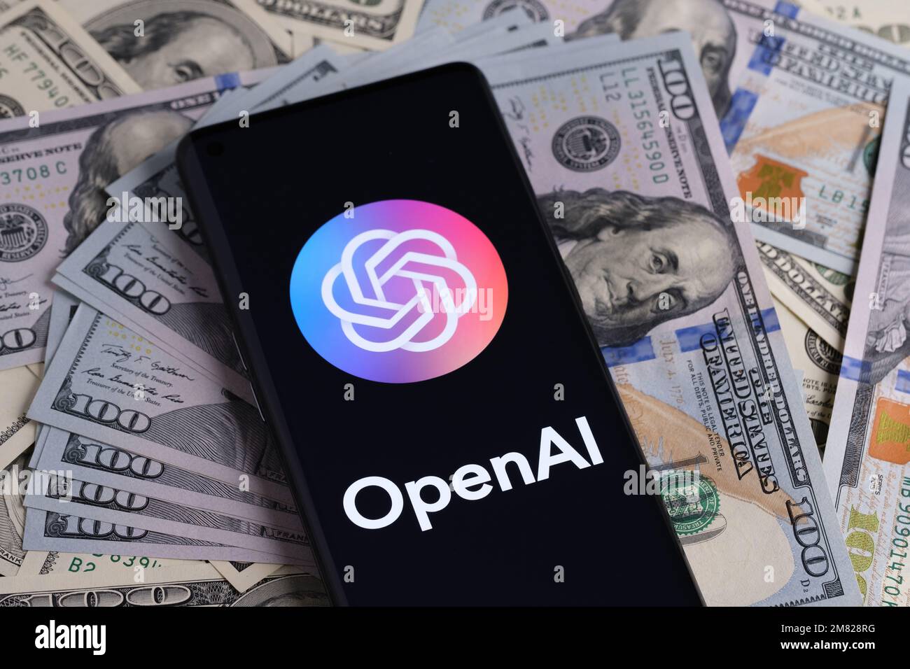 OPENAI visto sullo smartphone che è messo su mucchio di cash.Open ai è una società conosciuta per il suo ChatGPT e DALL-e ai generative software. Stafford, Foto Stock