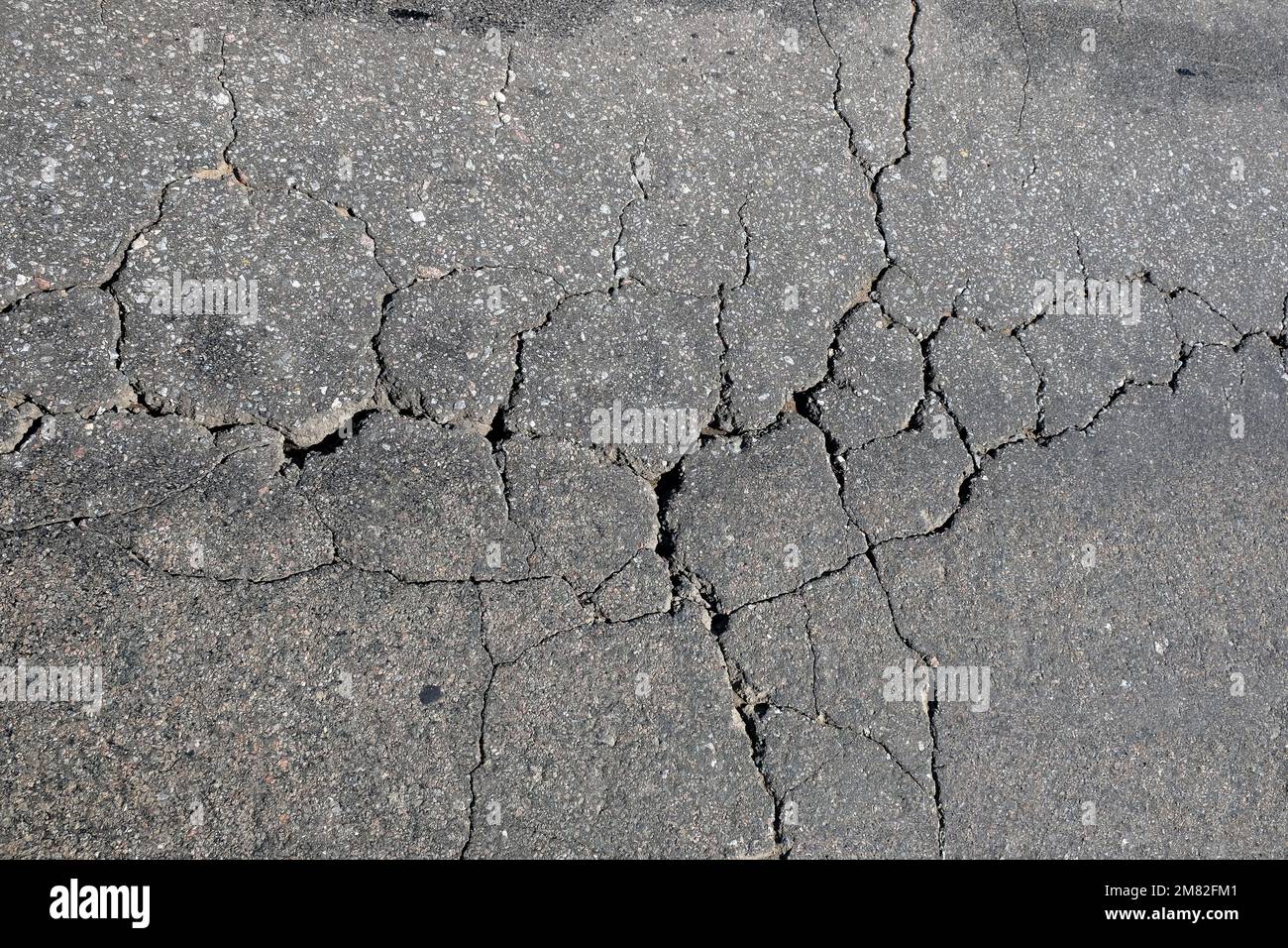 La superficie asfaltata della carreggiata in cattive condizioni richiede riparazioni ravvicinate della vista dall'alto Foto Stock