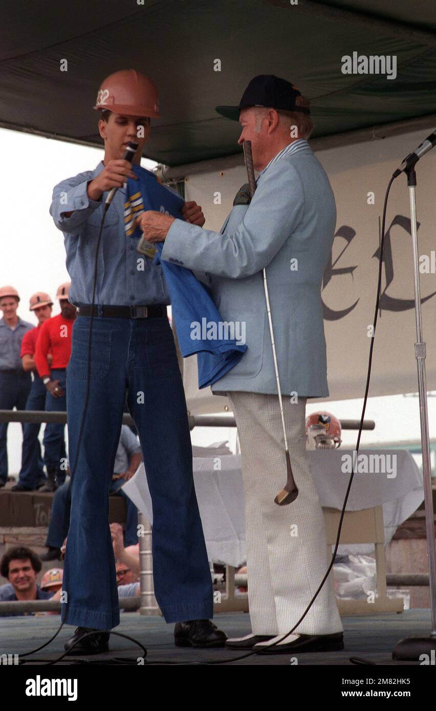 Un marinaio presenta una maglia FORRESTAL a Bob Hope durante lo spettacolo di 30 minuti a bordo della portaerei USS FORRESTAL (CV-59). Base: Philadelphia Stato: Pennsylvania (PA) Paese: Stati Uniti d'America (USA) Foto Stock
