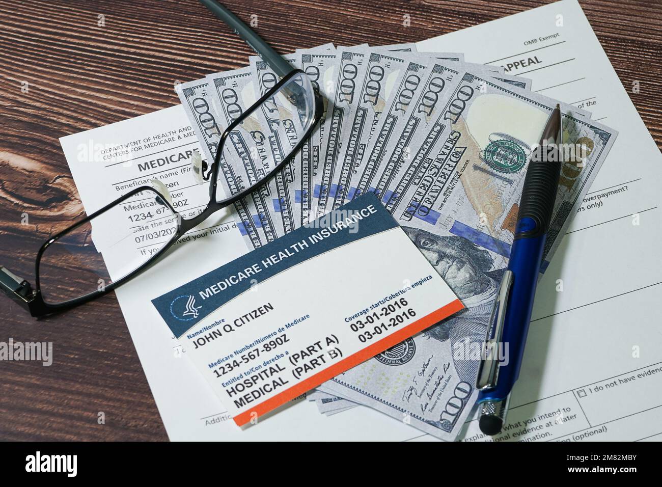 Falso Medicare carta e falso contanti con occhiali e penna. Foto Stock