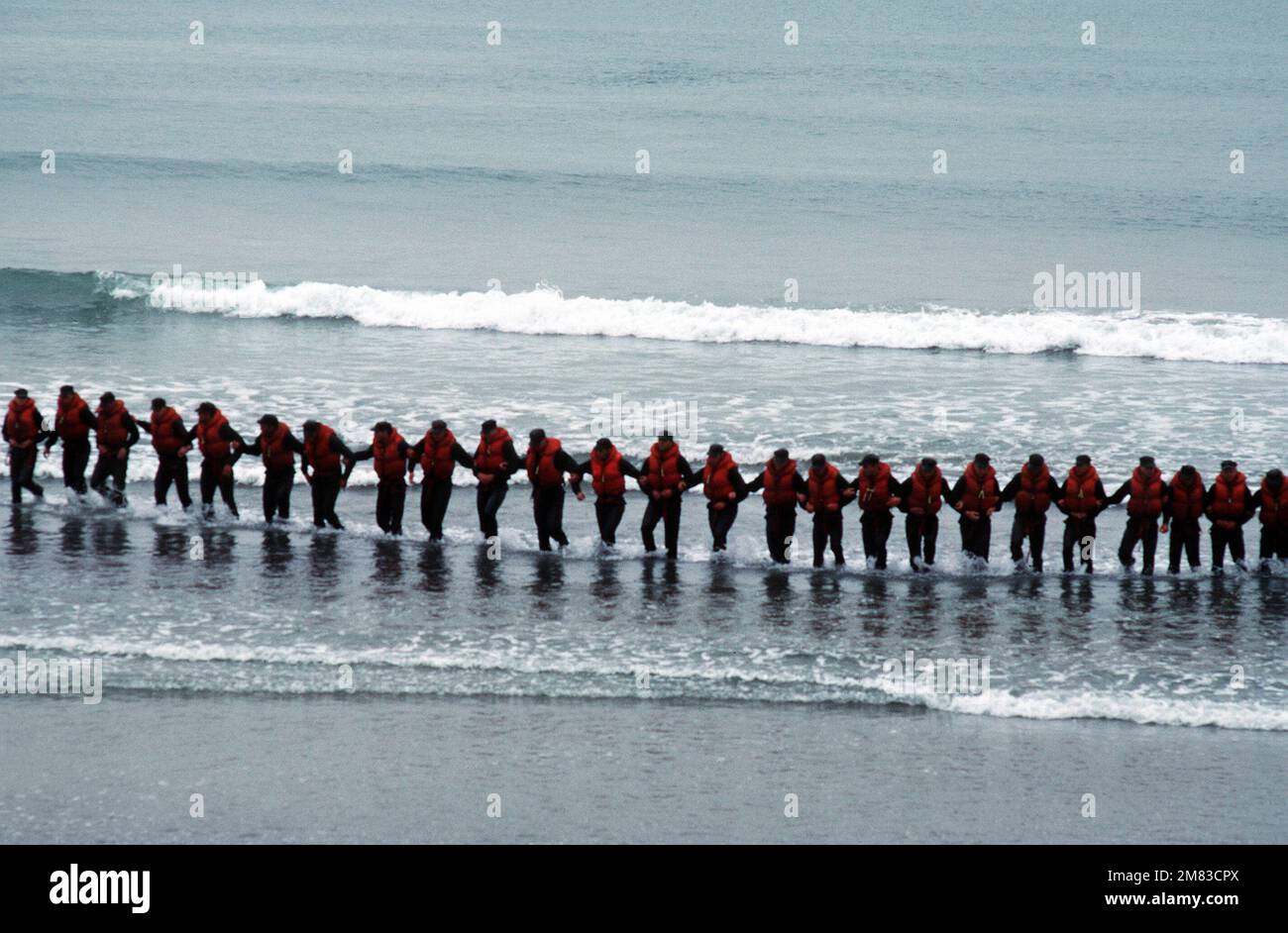 NEGLI STATI UNITI Navy Basic Underwater Demolition/Sea-Air-Land (SEAL) (BUD/S) gli apprendisti collegano le armi sulla spiaggia durante un'esercitazione della "settimana dell'inferno". La fase i della formazione BUD/S si conclude con la "settimana dell'inferno", quando le capacità fisiche, emotive e mentali degli studenti vengono testate in condizioni avverse. Base: Naval Amphibious base, Coronado Stato: California (CA) Paese: Stati Uniti d'America (USA) Foto Stock
