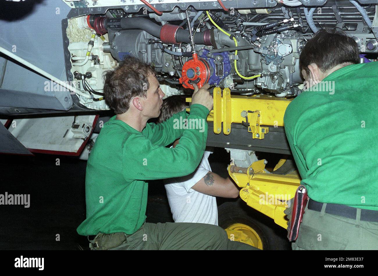 Aviation Machinist First Class Paris e Mathey of Strike-fighter Squadron 113 (VFA-113) rimuovono un motore da un aeromobile F/A-18 Hornet a bordo della COSTELLAZIONE USS della portaerei (CV-64). Paese: Sconosciuto Foto Stock