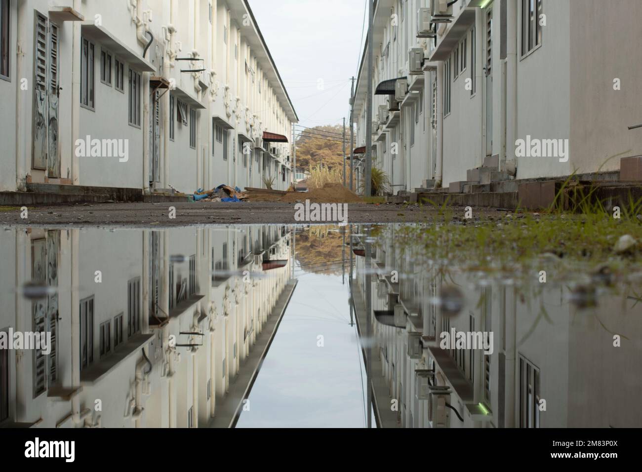 ristagnante piscina d'acqua scena dopo la pioggia al sobborgo strada asfaltata Foto Stock