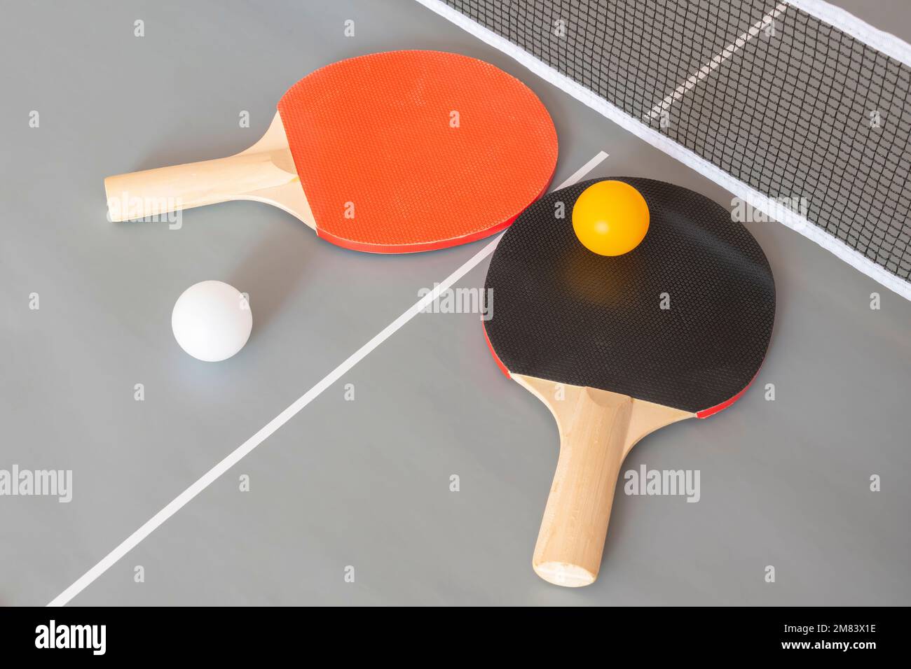 Due racchette da ping pong e palle su un tavolo grigio Foto Stock