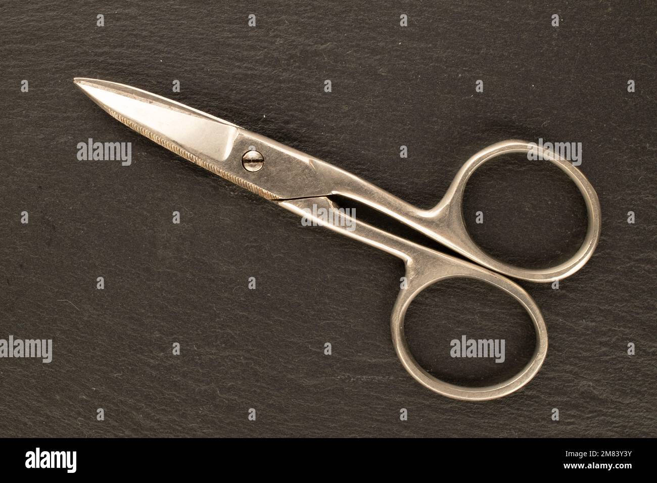 Una forbici in metallo d'epoca su ardesia, macro, vista dall'alto. Foto Stock