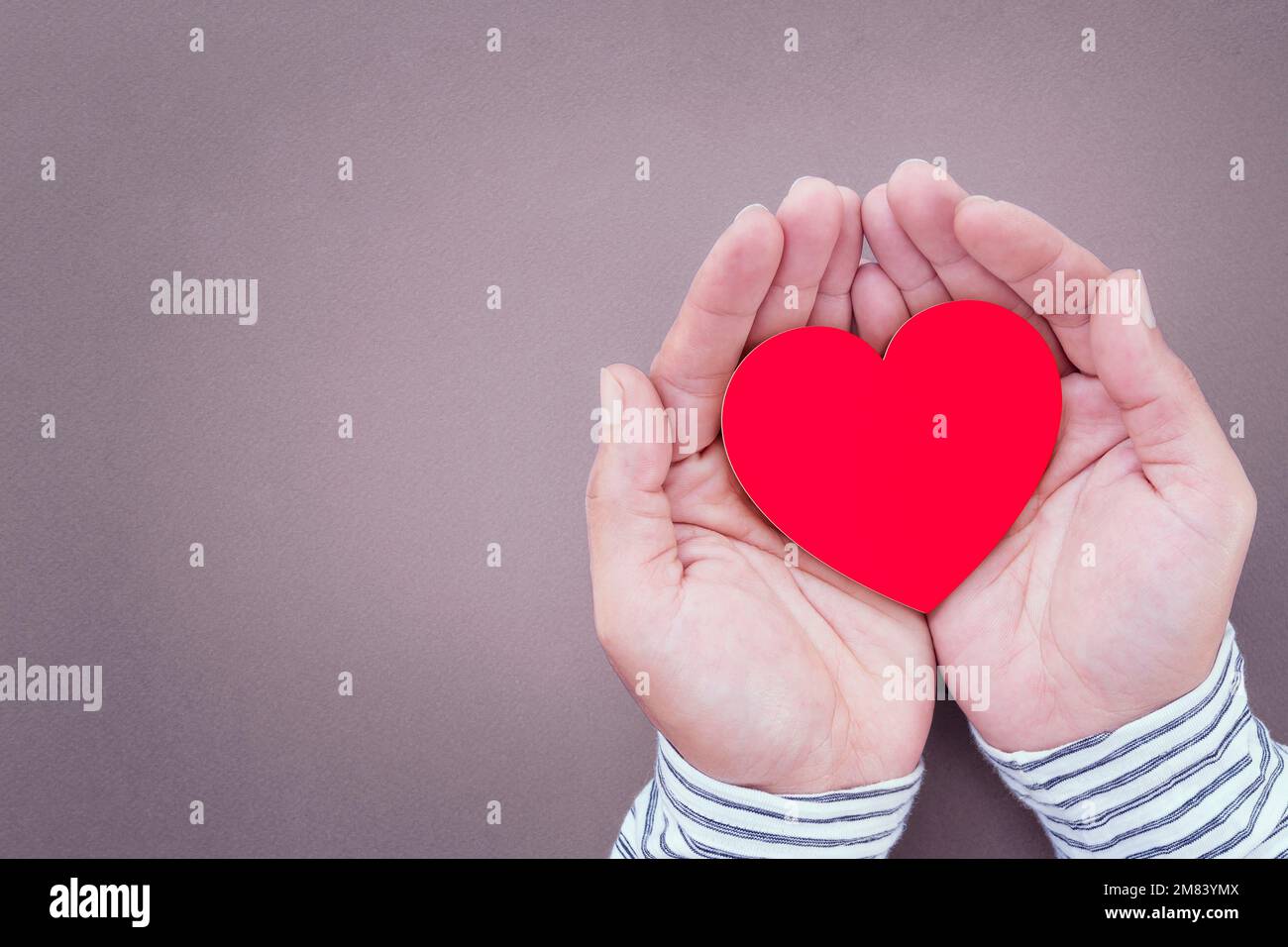 Mani dell'uomo che tengono la forma di cuore di carta rossa e cardiogramma di cuore, salute di cuore, donazione, beneficenza volontaria felice Foto Stock