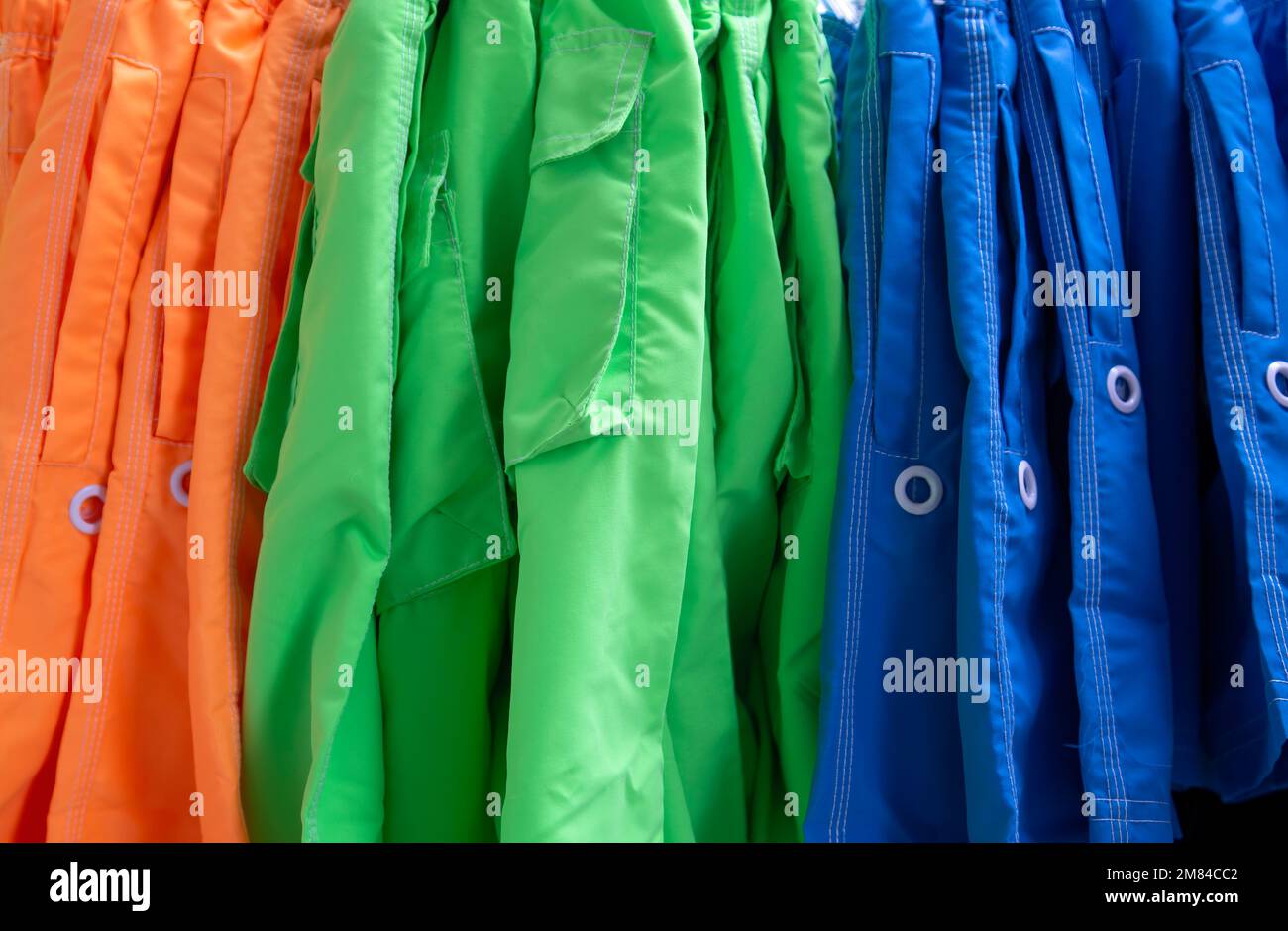 Molti pantaloni colorati appesi all'esterno di un negozio Foto Stock